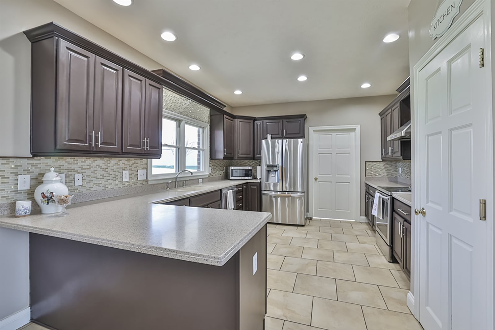 The kitchen has a breakfast room space that is offset by a peninsula countertop. Cabinetry fills two walls and wraps around stainless-steel appliances. A double sink is below two windows. CONTRIBUTED PHOTO