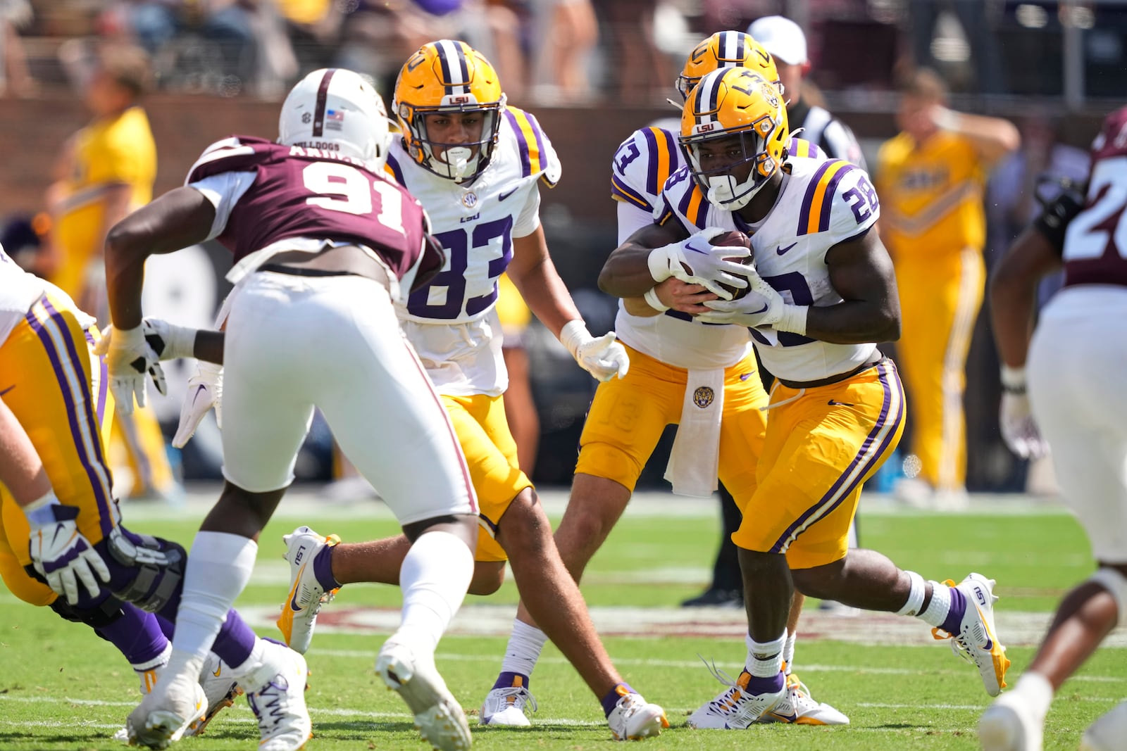 LSU running back Kaleb Jackson (28) follows a block by tight end Jackson McGohan (83) on Mississippi State defensive end Deonte Anderson (91) as he runs for short yardage during the second half of an NCAA college football game, Saturday, Sept. 16, 2023, in Starkville, Miss. LSU won 41-14. (AP Photo/Rogelio V. Solis)