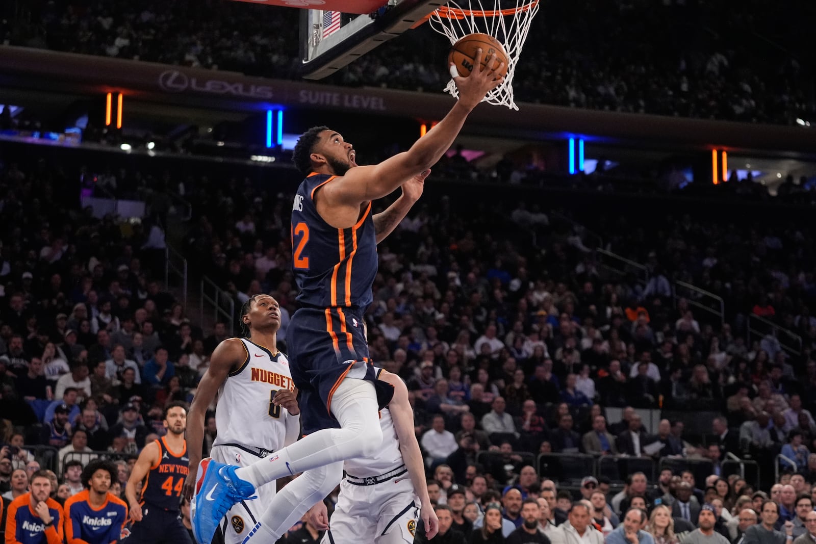 New York Knicks' Karl-Anthony Towns (32) drives past Denver Nuggets' Peyton Watson (8) during the first half of an NBA basketball game Wednesday, Jan. 29, 2025, in New York. (AP Photo/Frank Franklin II)