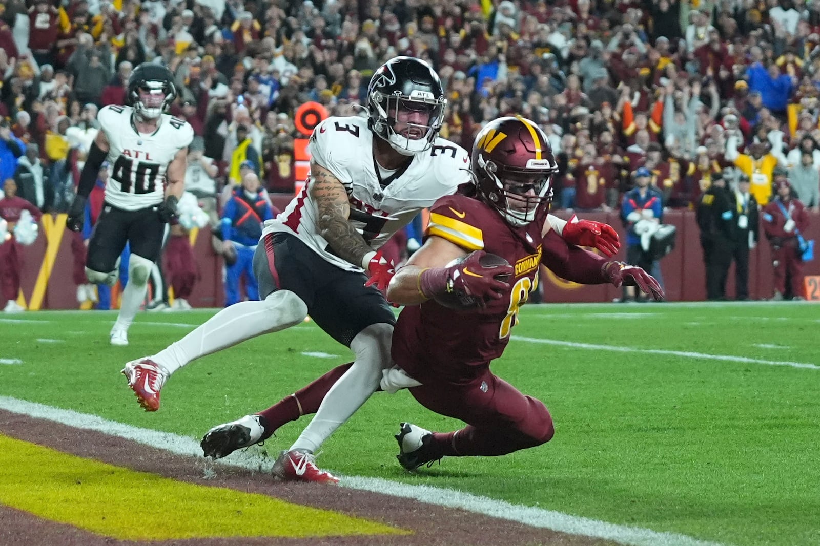 Washington Commanders tight end Zach Ertz scores on a touchdown reception against Atlanta Falcons safety Jessie Bates III (3) during the second half of an NFL football game, Sunday, Dec. 29, 2024, in Landover, Md. (AP Photo/Stephanie Scarbrough)