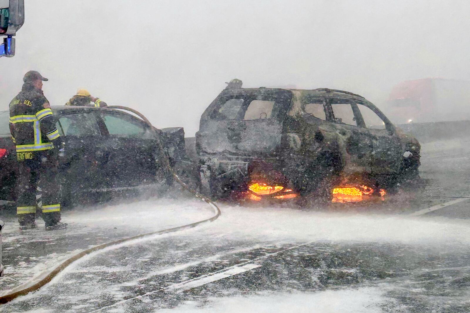 In this image provided by the Multnomah County Sheriff's Office officials respond to a SUV that caught fire on westbound Interstate 84 on Thursday, Feb. 13, 2025, near Multnomah Falls, Ore. (Multnomah County Sheriff's Office via AP)