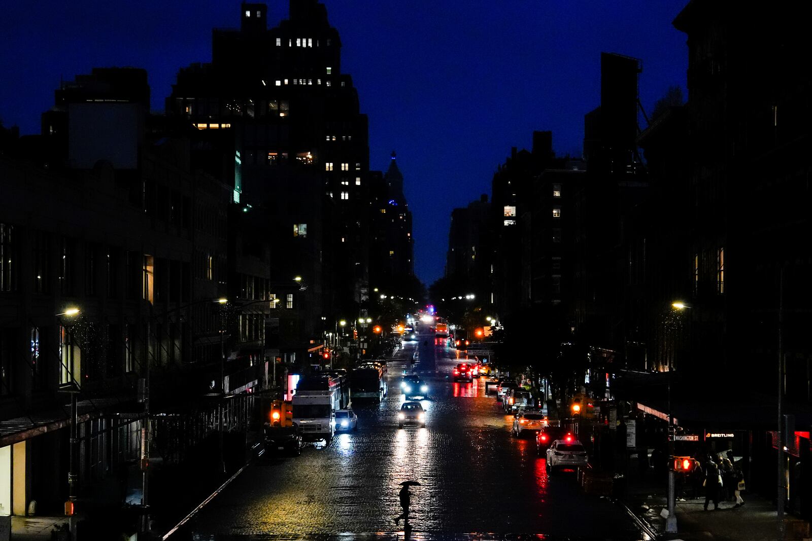 A person uses an umbrella while crossing the street in the Meatpacking District neighborhood of Manhattan, Friday, Nov. 22, 2024, in New York. (AP Photo/Julia Demaree Nikhinson)