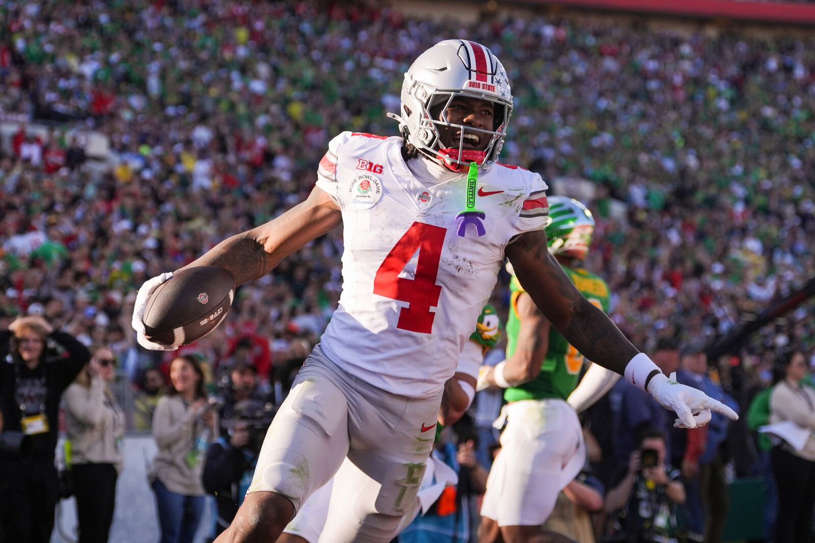 Ohio State wide receiver Jeremiah Smith (4) celebrates his touchdown against Oregon during the first half in the quarterfinals of the Rose Bowl College Football Playoff, Wednesday, Jan. 1, 2025, in Pasadena, Calif. (AP Photo/Mark J. Terrill)