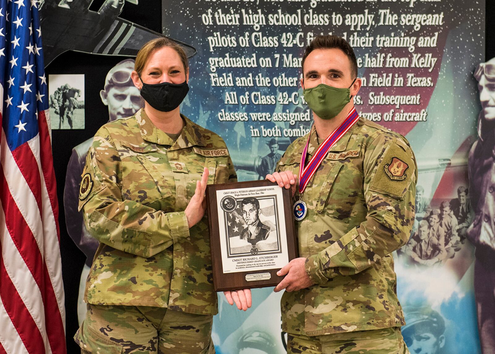 Chief Master Sgt. Lindsey Wolf, Air Force Materiel Command paralegal career field functional manager, presents Staff Sgt. Joel Ray, 64th Intelligence Squadron, with a Distinguished Graduate Award during Airman Leadership School Class 22-B’s graduation ceremony Feb. 10. The Distinguished Graduate Award goes to students ranking in the top 10 percent of the class in academics, demonstrated leadership and performance. U.S. AIR FORCE PHOTO/JAIMA FOGG