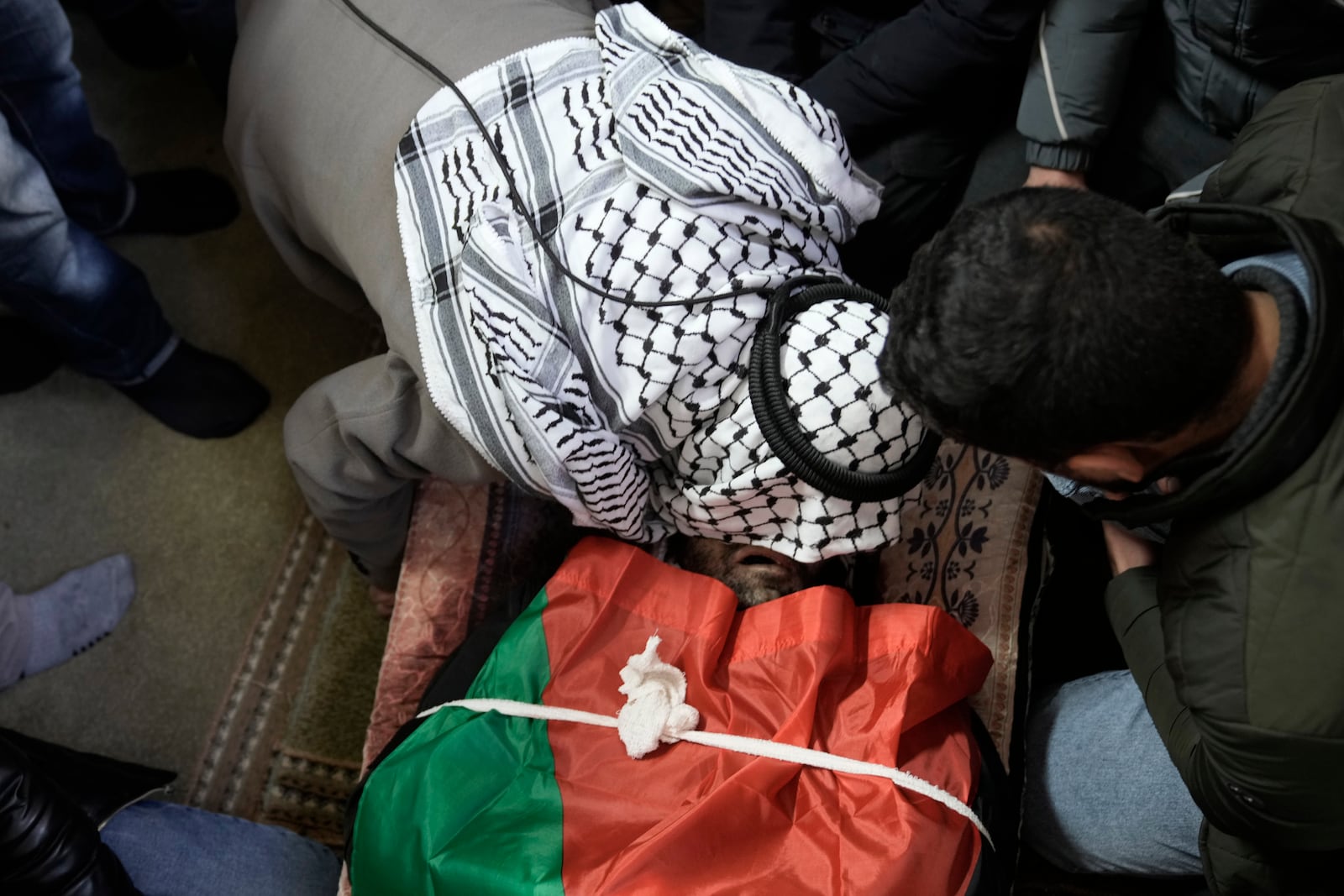 A mourner kisses the body of Jaafar Dababsah, a Palestinian Hamas commander killed in a raid by Israeli forces, during his funeral in the village of Talouza, near the West Bank city of Nablus, Tuesday, Jan. 7, 2025. (AP Photo/Majdi Mohammed)