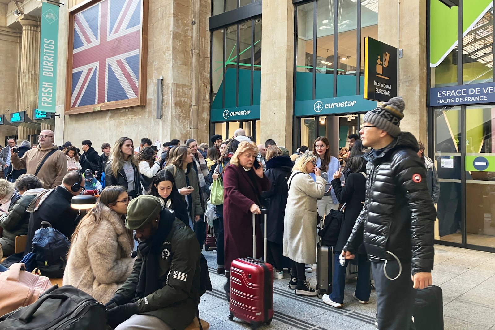 Travelers wait as Eurostar trains to London and all trains heading to northern France have been brought to a halt following the discovery of an unexploded bomb dating back to World War II near the tracks, Friday, March 7, 2025 at the Gare du Nord station in Paris. (AP Photo/Christophe Ena)