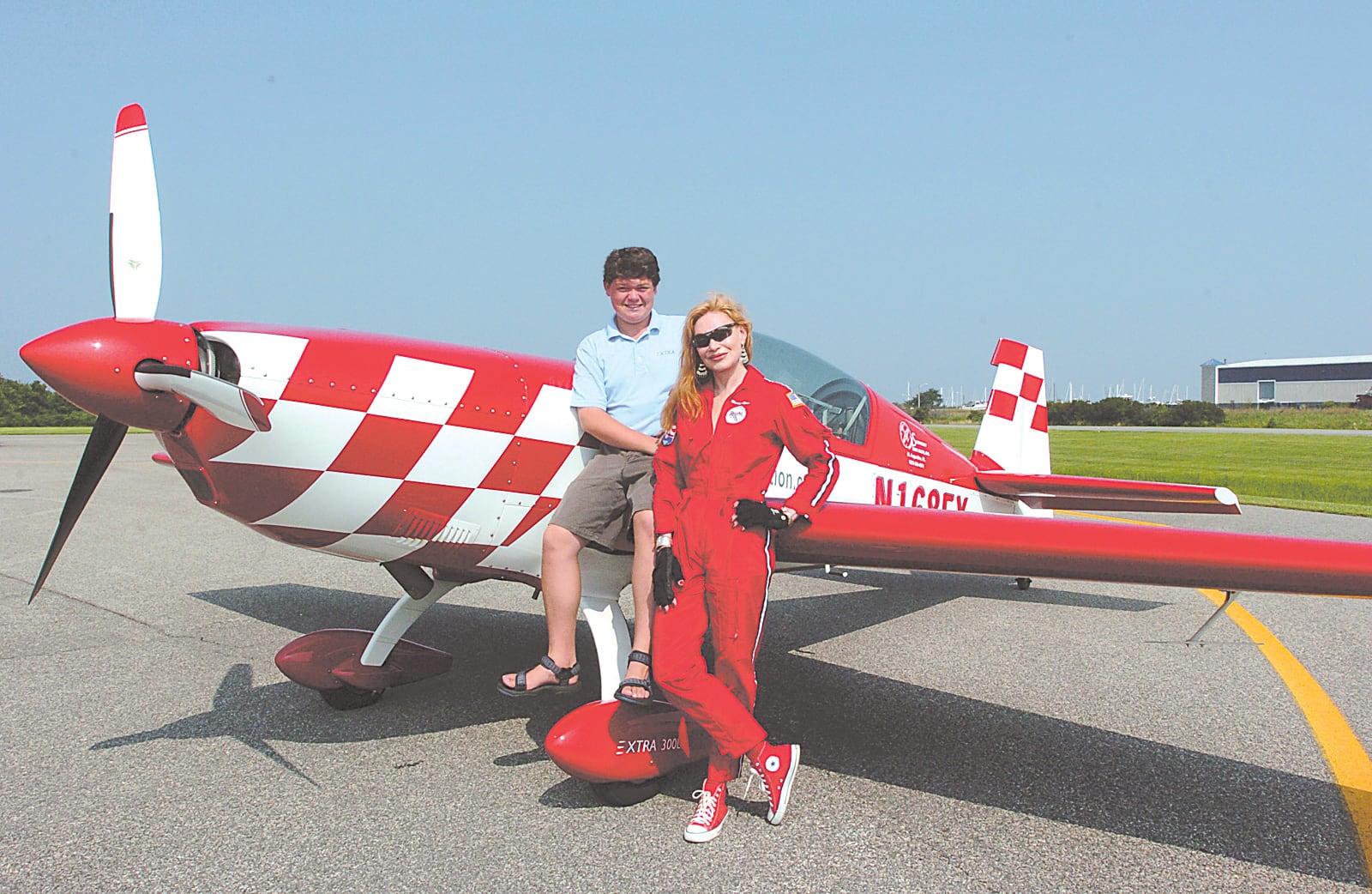 7/29/04: Nancy Lynn, an aerobatic pilot and her son Pete stand outside the hanger with the aerobatic plane that Nancy flys. Credit: Alison Harbaugh