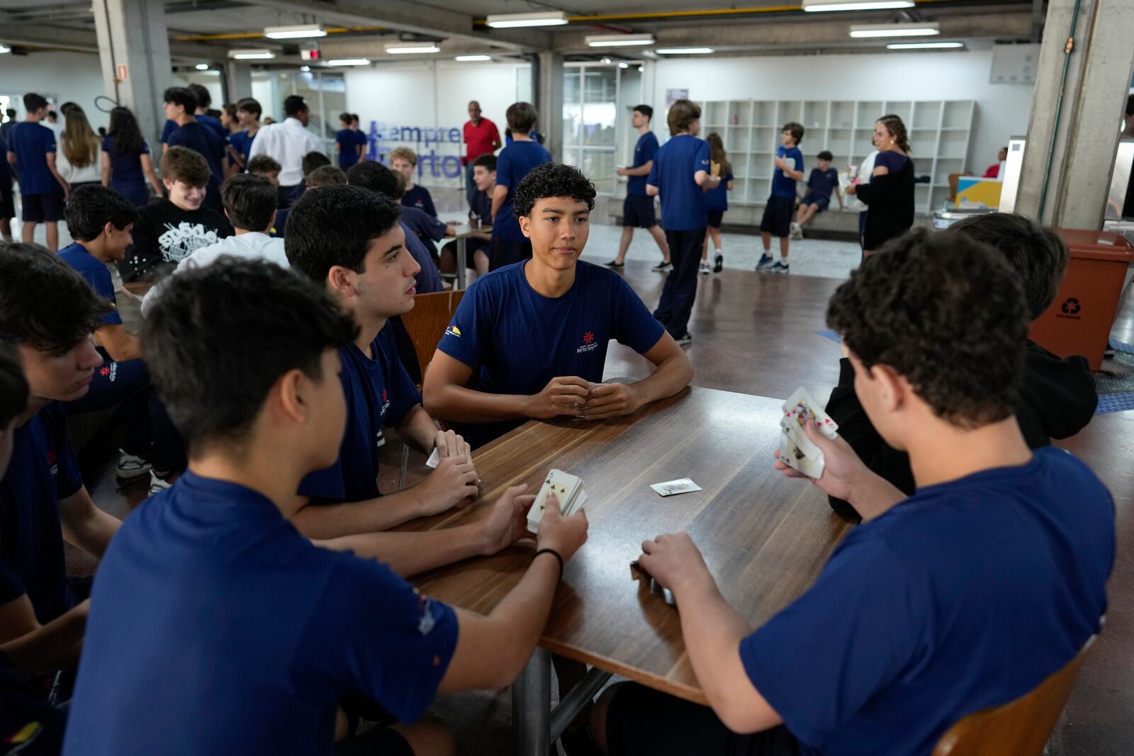 Students play cards during recess in their first week at school under a new law that forbids the use of mobile phones on campus, at Porto Seguro School in Sao Paulo, Thursday, Feb. 6, 2025. (AP Photo/Andre Penner)