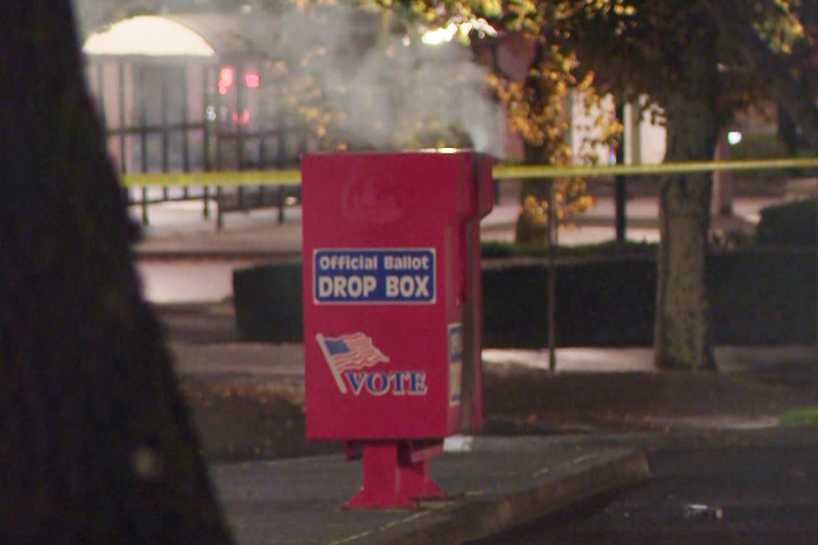 ORPOR OUT - In this image made from a video provided by KGW8, authorities investigate the scene as smoke pours out of a ballot box on Monday, Oct. 28, 2024, in Vancouver, Wash. (KGW8 via AP)