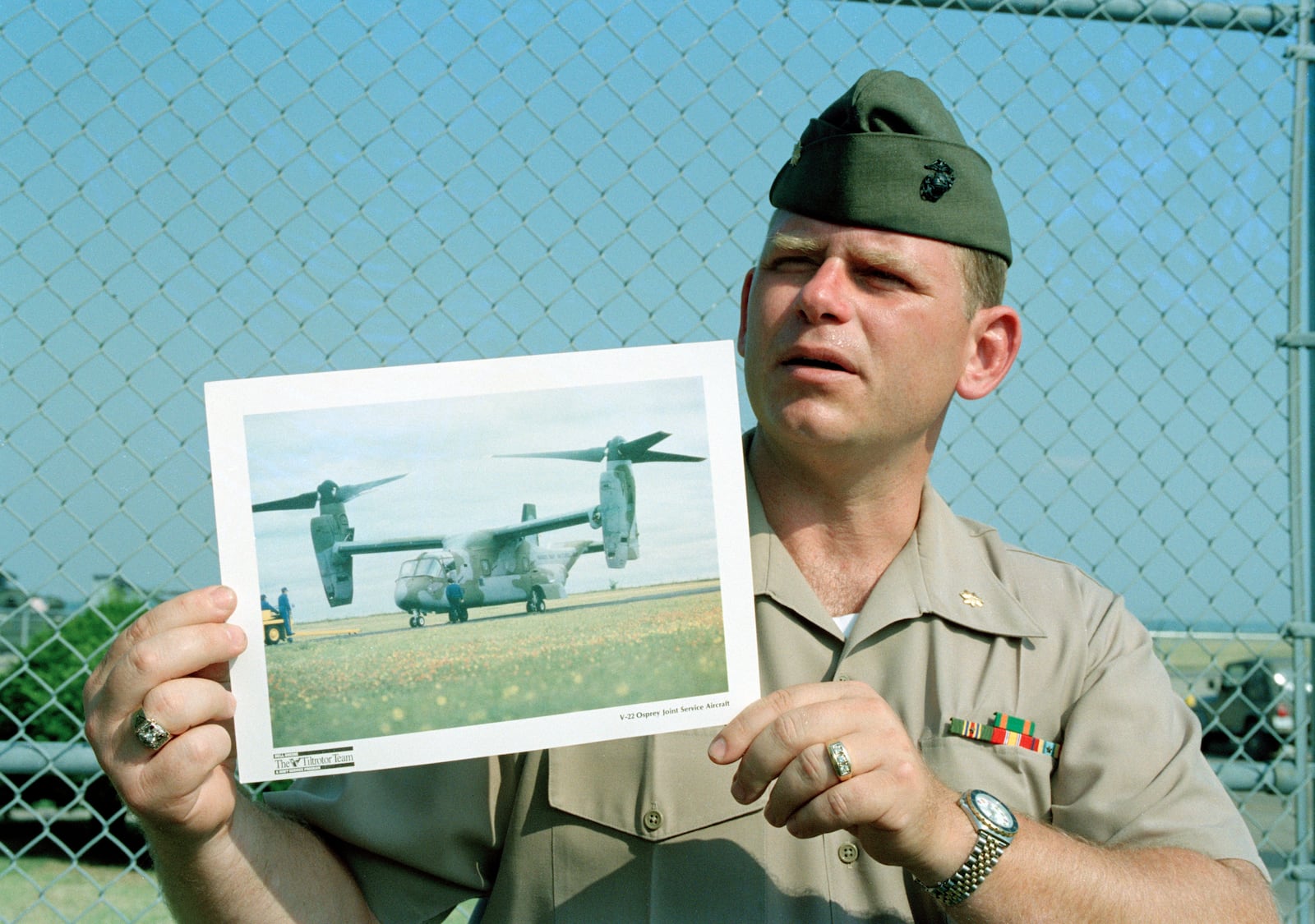 FILE - Maj. Barry Moore shows a photo of a V-22 Osprey aircraft at a news conference, July 20, 1992, at Quantico Marine Air Station in Quantico, Va., after an experimental V-22 tilt-rotor aircraft crashed into the Potomac River near the air station. (AP Photo/Charles Tasnadi, File)