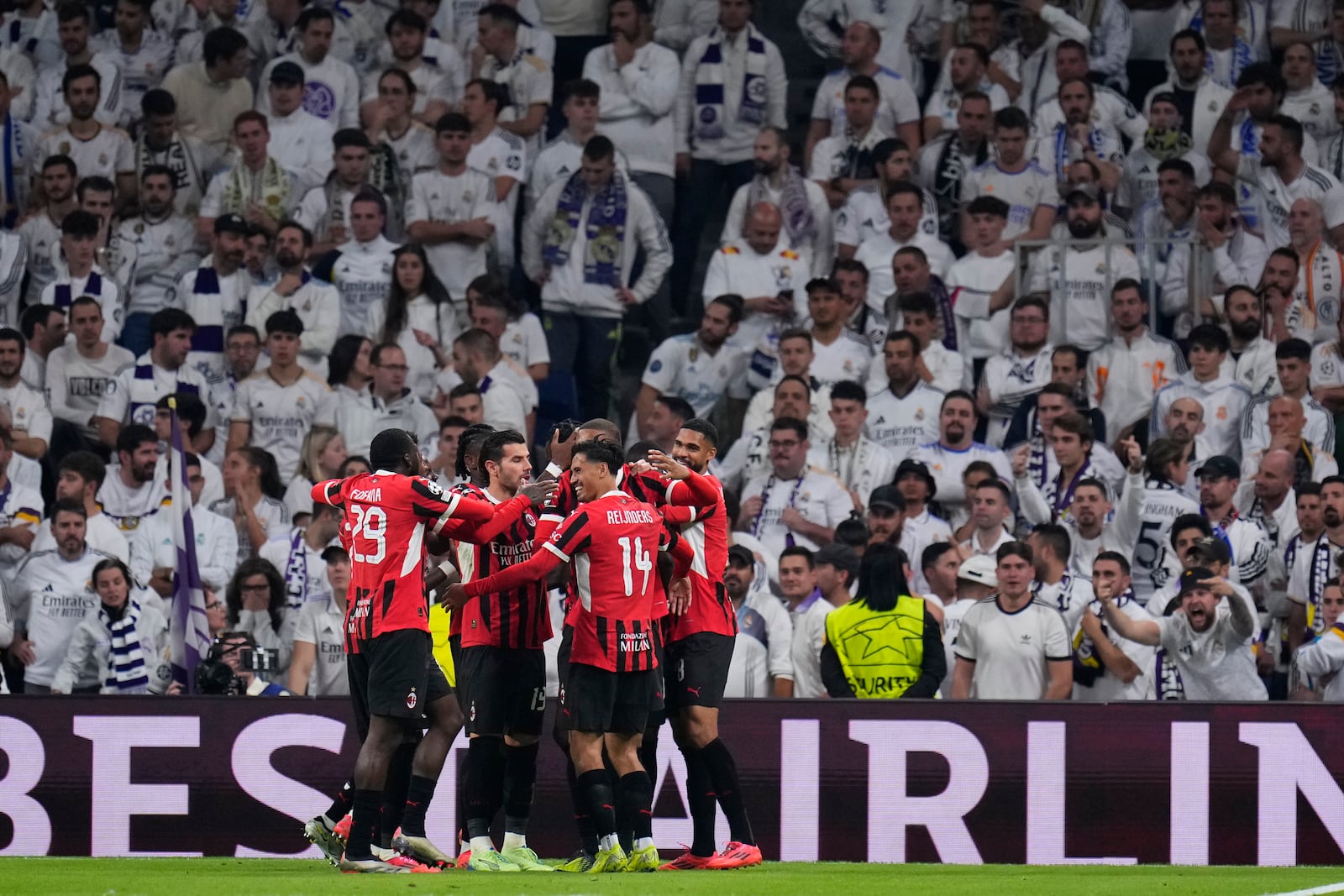 AC Milan's Tijjani Reijnders (14) celebrates with teammates after scoring his side's 3rd goal against Real Madrid during the Champions League opening phase soccer match at the Santiago Bernabeu stadium in Madrid, Spain, Tuesday, Nov. 5, 2024. (AP Photo/Manu Fernandez)