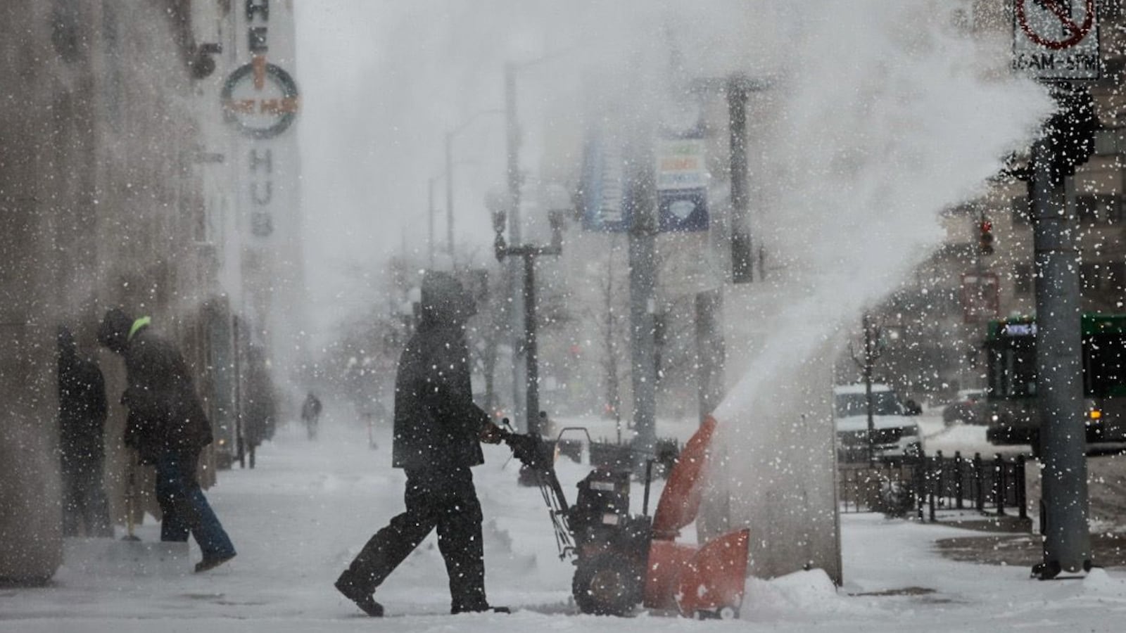 Juan Carlos blows snow on Main Street near The Hub in Dayton Friday December 23, 2022.  Jim Noelker/Staff