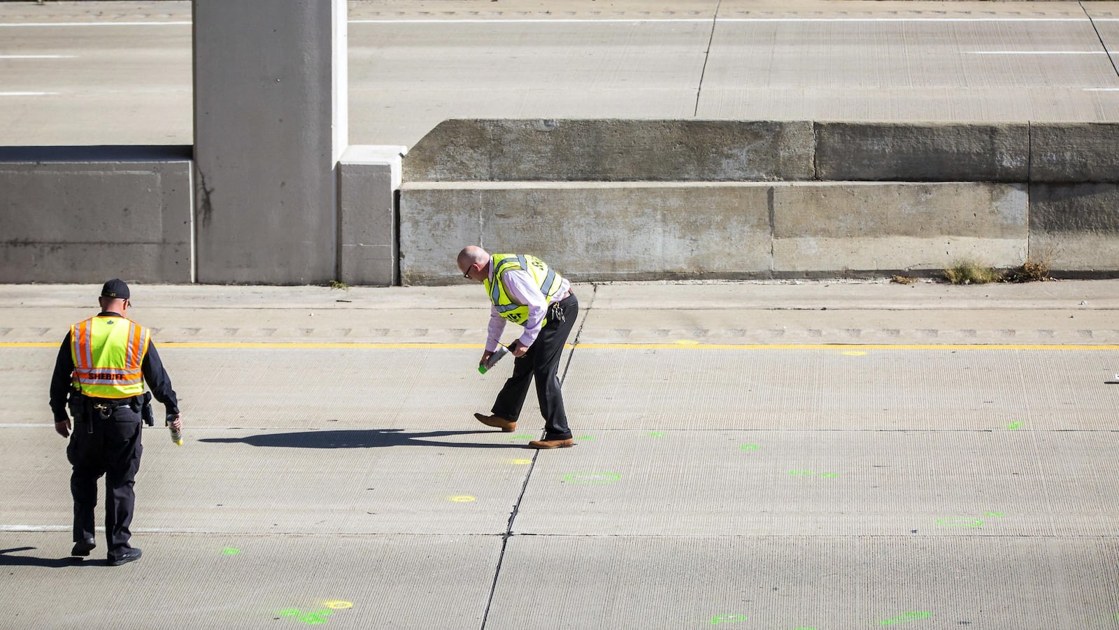 Genesee County Sheriff's officers investigate the scene of a traffic fatality Friday, Oct. 20, 2017, in Vienna Township, Mich.  where Dodge Road crosses Interstate 75. authorities are asking for the public's help in finding out who threw a rock from a highway overpass that smashed a car windshield and killed a 32-year-old man on Oct. 18.(Terray Sylvester/The Flint Journal-MLive.com via AP)