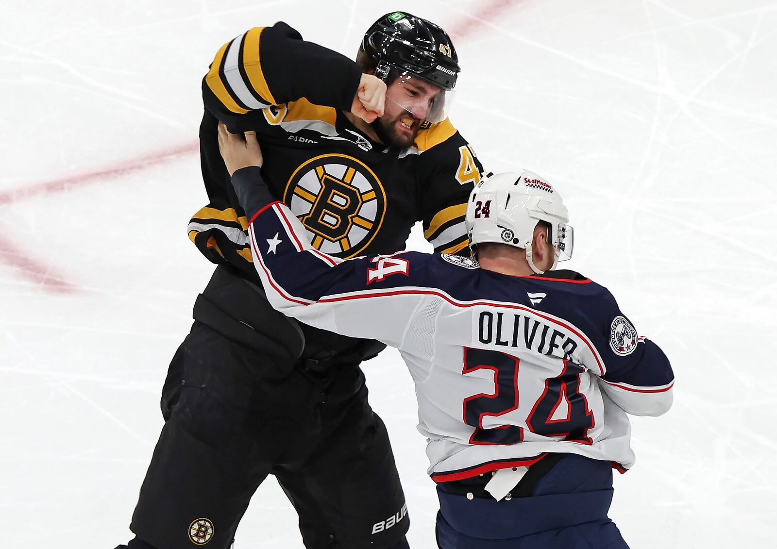 Boston Bruins forward Mark Kastelic (47) and Columbus Blue Jackets' Mathieu Olivier (24) fight during the first period of an NHL hockey game Saturday, Dec. 28, 2024, in Boston. (AP Photo/Jim Davis)