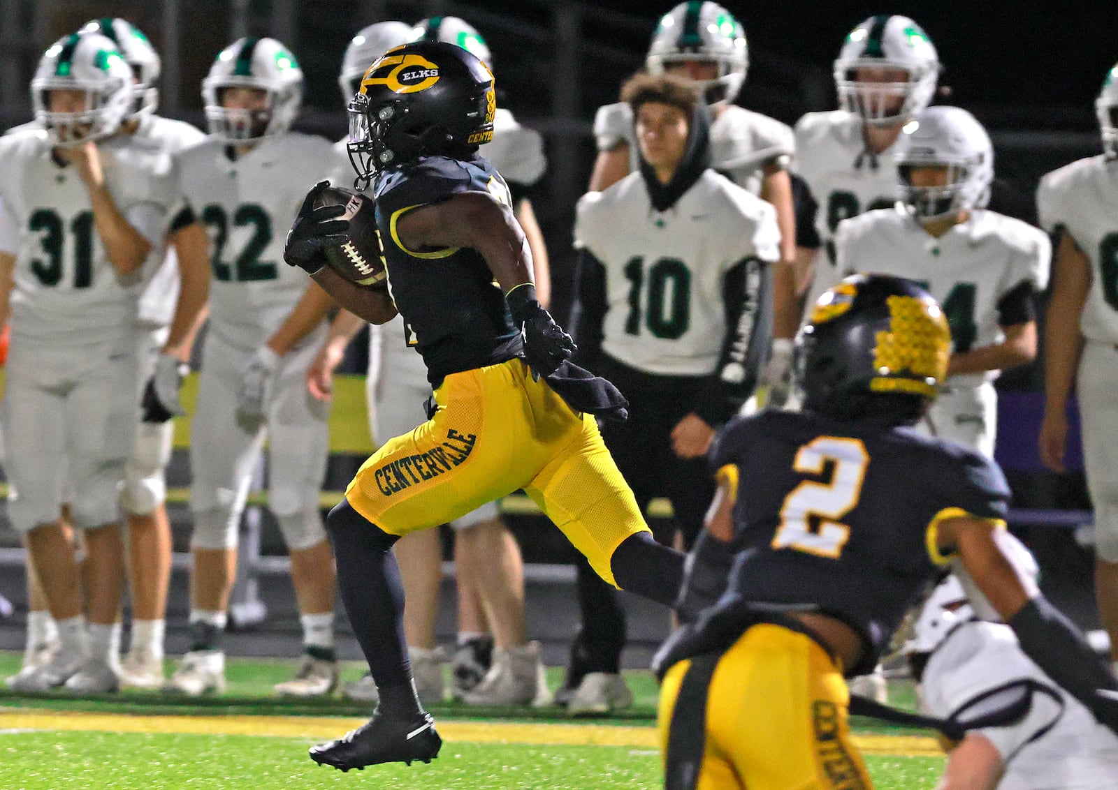 Centerville's Ziere Alston runs back the opening kickoff for an Elks touchdown against Dublin Coffman during Friday's playoff game at Springfield. BILL LACKEY/STAFF