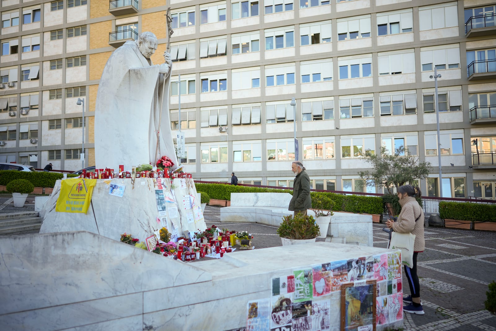 People pray for Pope Francis in front of the Agostino Gemelli Polyclinic, in Rome, Tuesday, March 11, 2025, where the Pontiff is hospitalized since Friday, Feb. 14. (AP Photo/Andrew Medichini)