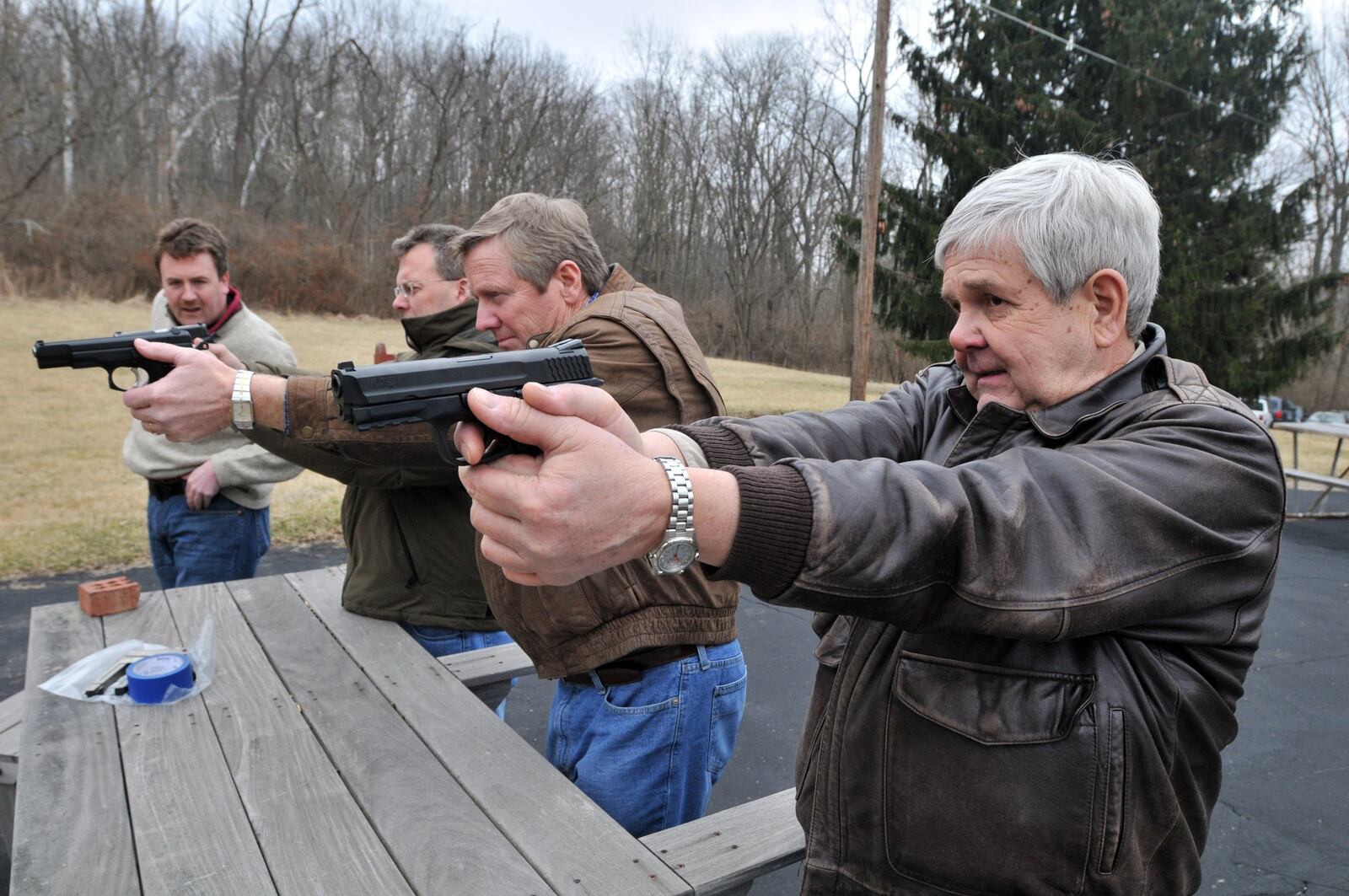 In this 2009 file photo, Collin Rink of Madeira, left, and then-state representatives Tim Derickson, Jim Zehringer and Ron Maag give a demonstration on proper holding technique on unloaded guns at a Concealed Carry Weapons Training Course. The class was sponsored by The Warren County Republican Party. SAMANTHA GRIER/STAFF