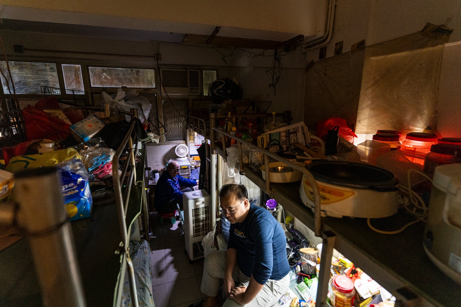 Resident Law Chung-yu sits in his bed space in Sham Shui Po district of Hong Kong, on Feb. 6, 2025. (AP Photo/Chan Long Hei)