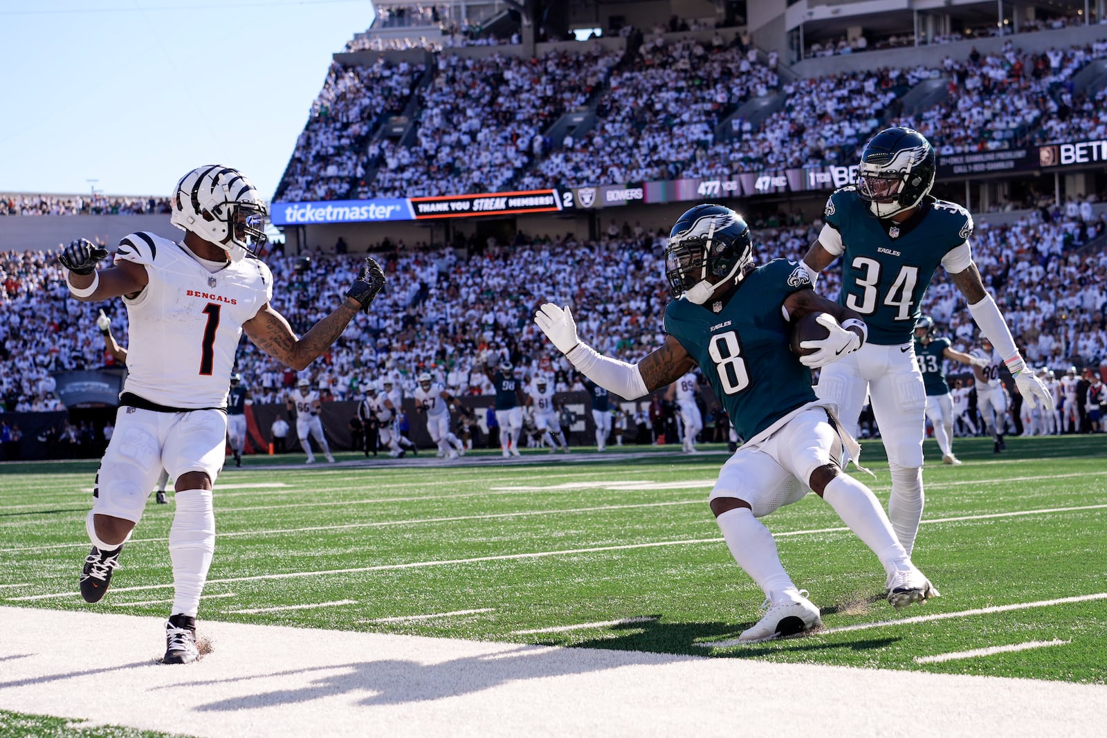 Philadelphia Eagles safety C.J. Gardner-Johnson (8) holds the ball after intercepting a pass intended for Cincinnati Bengals wide receiver Ja'Marr Chase (1) during the second half of an NFL football game, Sunday, Oct. 27, 2024 in Cincinnati. Eagles' Isaiah Rodgers (34) looks on. (AP Photo/Carolyn Kaster)