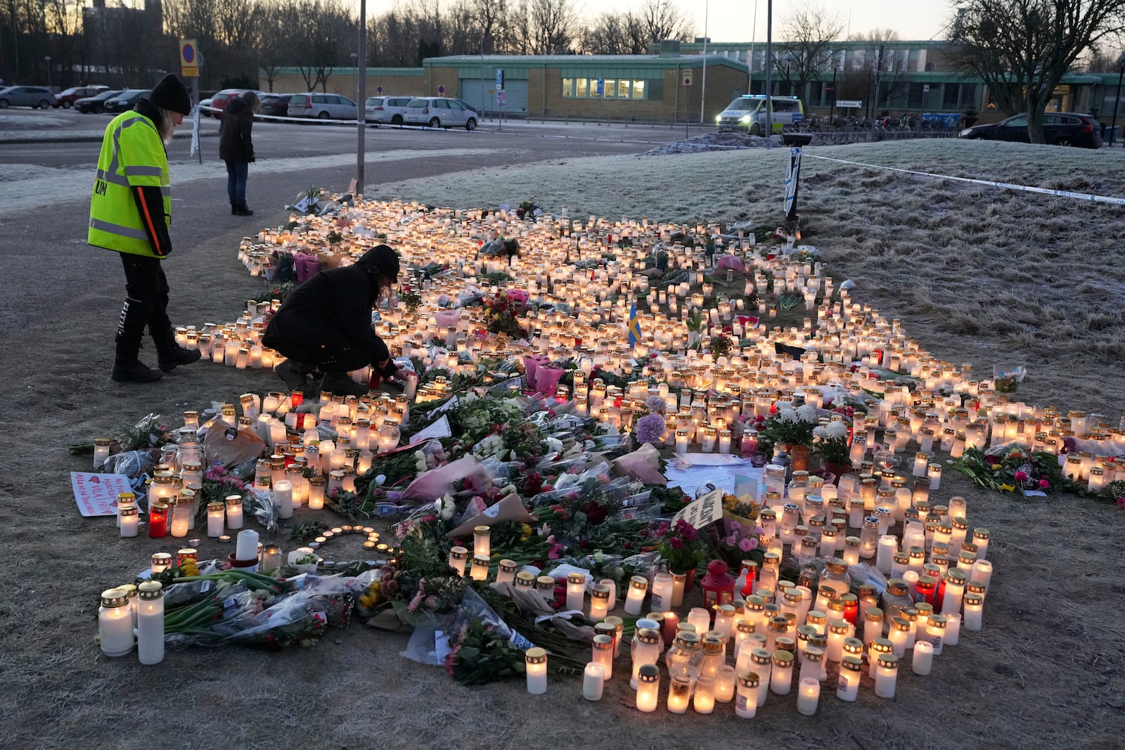 People light candles at a makeshift memorial near the scene of a shooting on the outskirts of Orebro, Sweden, Friday, Feb. 7, 2025. (AP Photo/Sergei Grits)