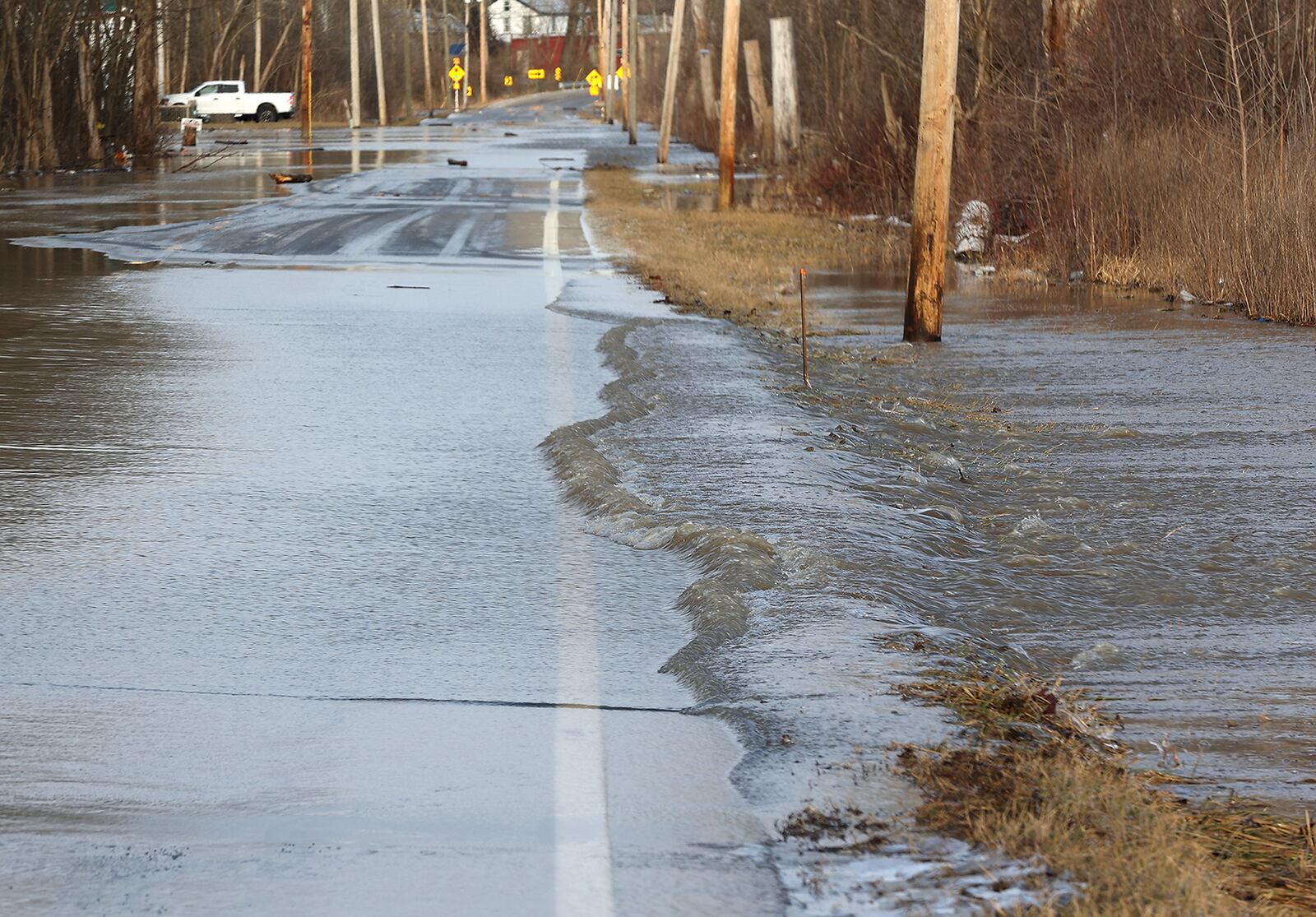 Several inches of rain flows across Spangler Road in Clark County forcing the County to close it due to all the rain Thursday. BILL LACKEY/STAFF