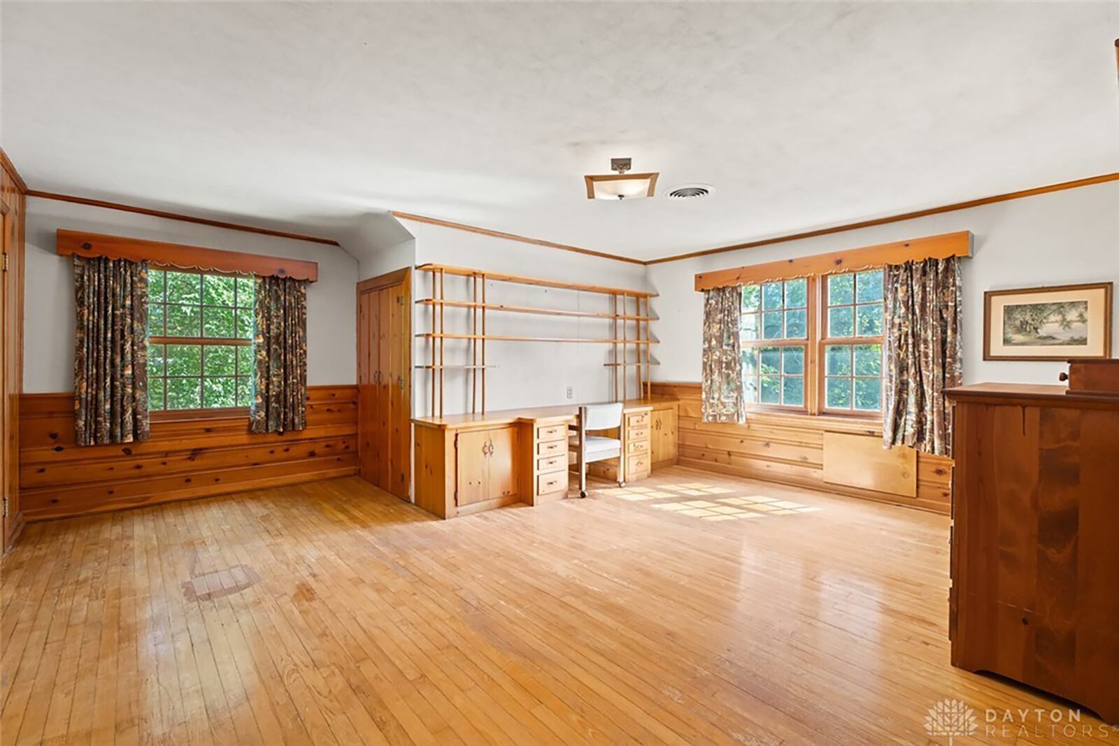 The second level of the home has three bedrooms. This one has original hardwood flooring and some built ins and a walk in closet.