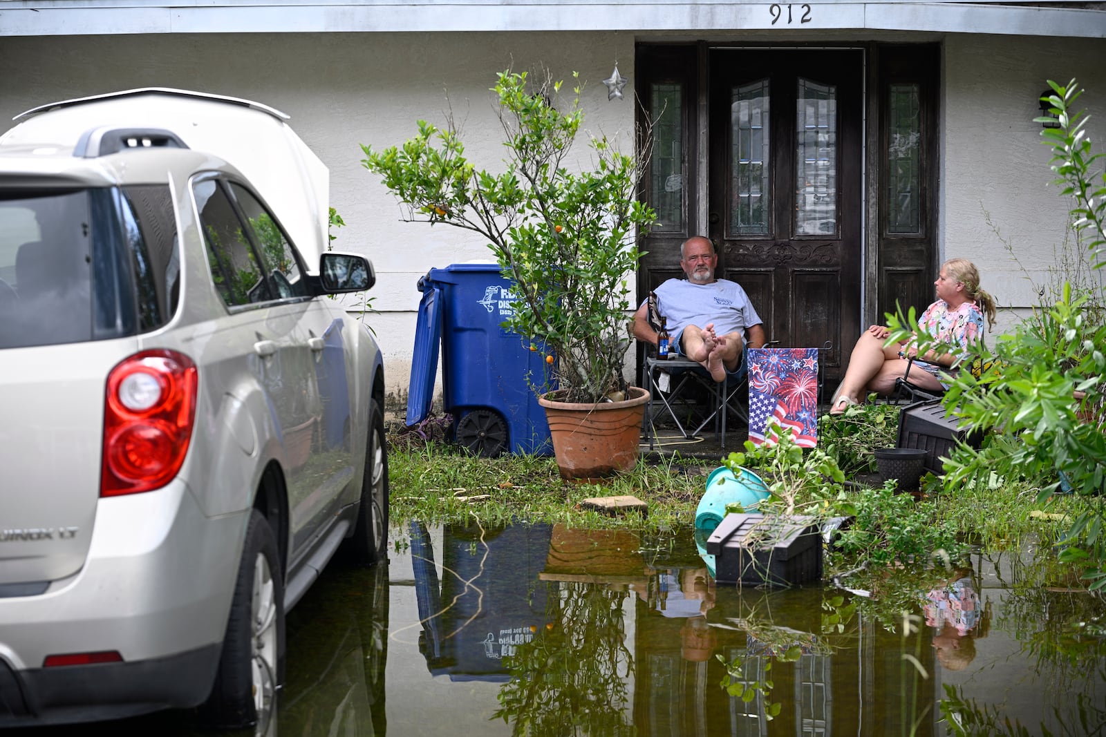 Andy Slone and his wife, Vickie, sit outside their home in the aftermath of Hurricane Helene, Friday, Sept. 27, 2024, in Crystal River, Fla. (AP Photo/Phelan M. Ebenhack)