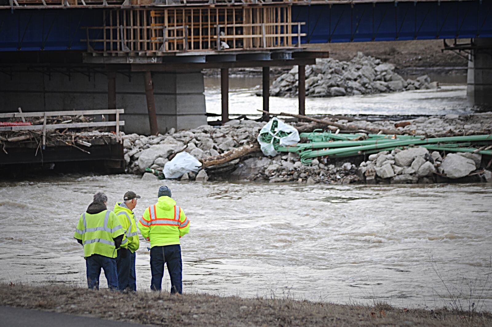 Workers watch the Great Miami River near the Keowee Street Bridge on Thursday morning.  A  large water main break late Wednesday cut water service to much of the County and most of it was restored by Thursday morning, but continued to require boiling before use.  MARSHALL GORBY / STAFF