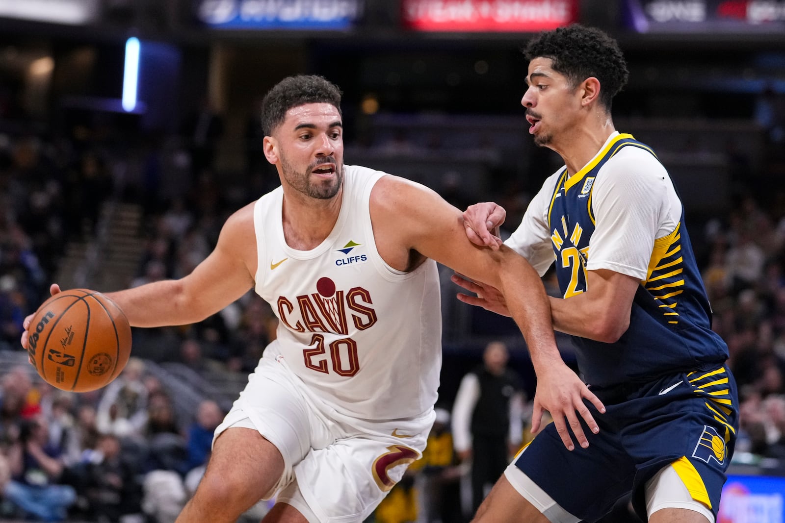 Cleveland Cavaliers forward Georges Niang (20) drives on Indiana Pacers guard Ben Sheppard (26) during the second half of an NBA basketball game in Indianapolis, Tuesday, Jan. 14, 2025. (AP Photo/Michael Conroy)