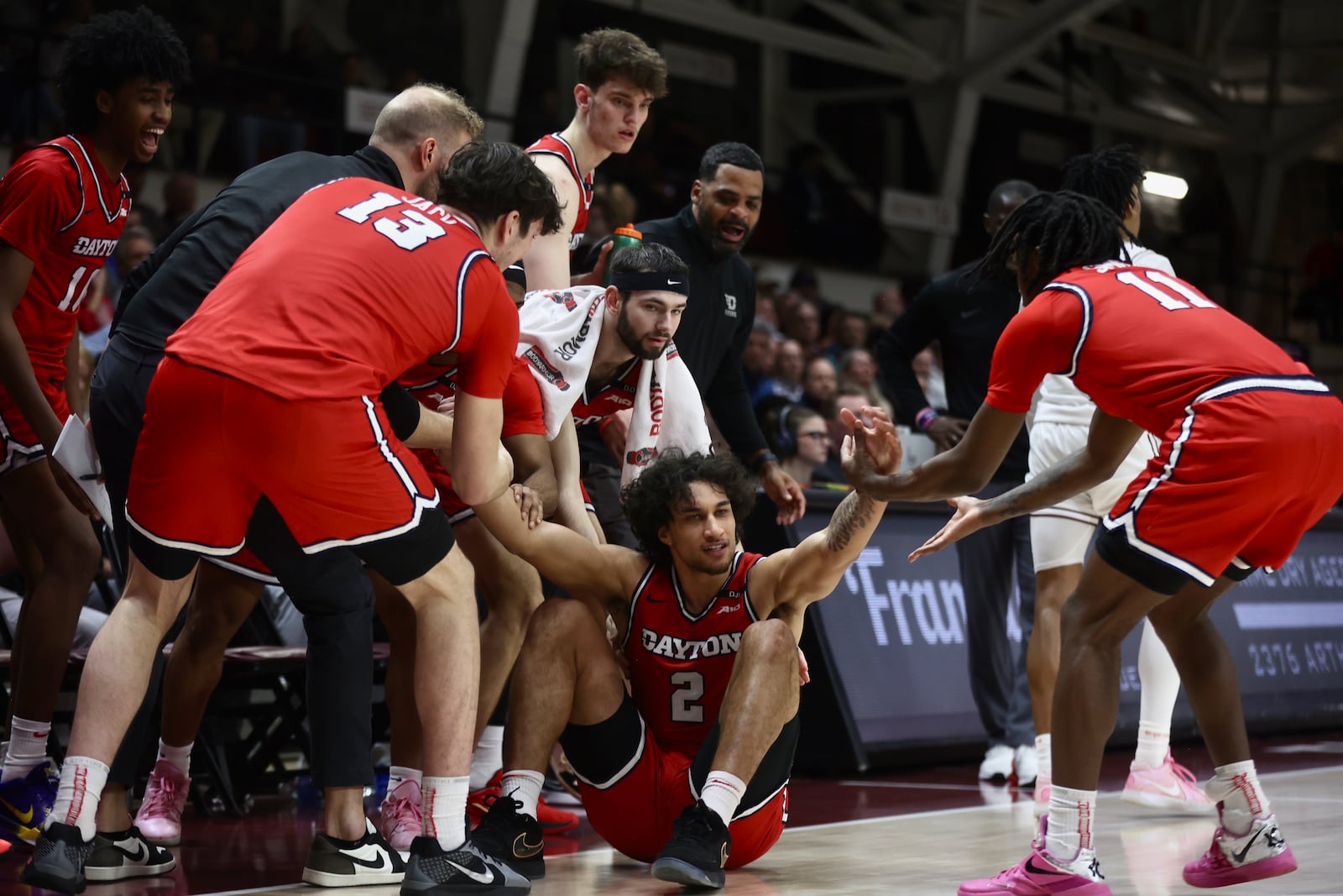 Dayton players help Nate Santos get up after a foul in the second half against Fordham on Wednesday, Feb. 12, 2025, at Rose Hill Gym in Bronx, N.Y. David Jablonski/Staff