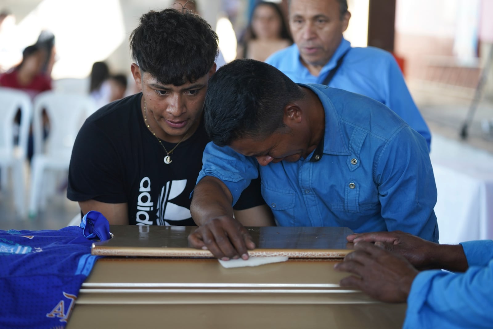 Mourners pay their final respects to the victim of a bus crash at a funeral service in Santo Domingo Los Ocotes, Guatemala, Tuesday, Feb. 11, 2025. Dozens of passengers died after their bus plunged into a gorge and landed under a bridge on Feb. 10 on the outskirts of Guatemalan capital. (AP Photo/Moises Castillo)