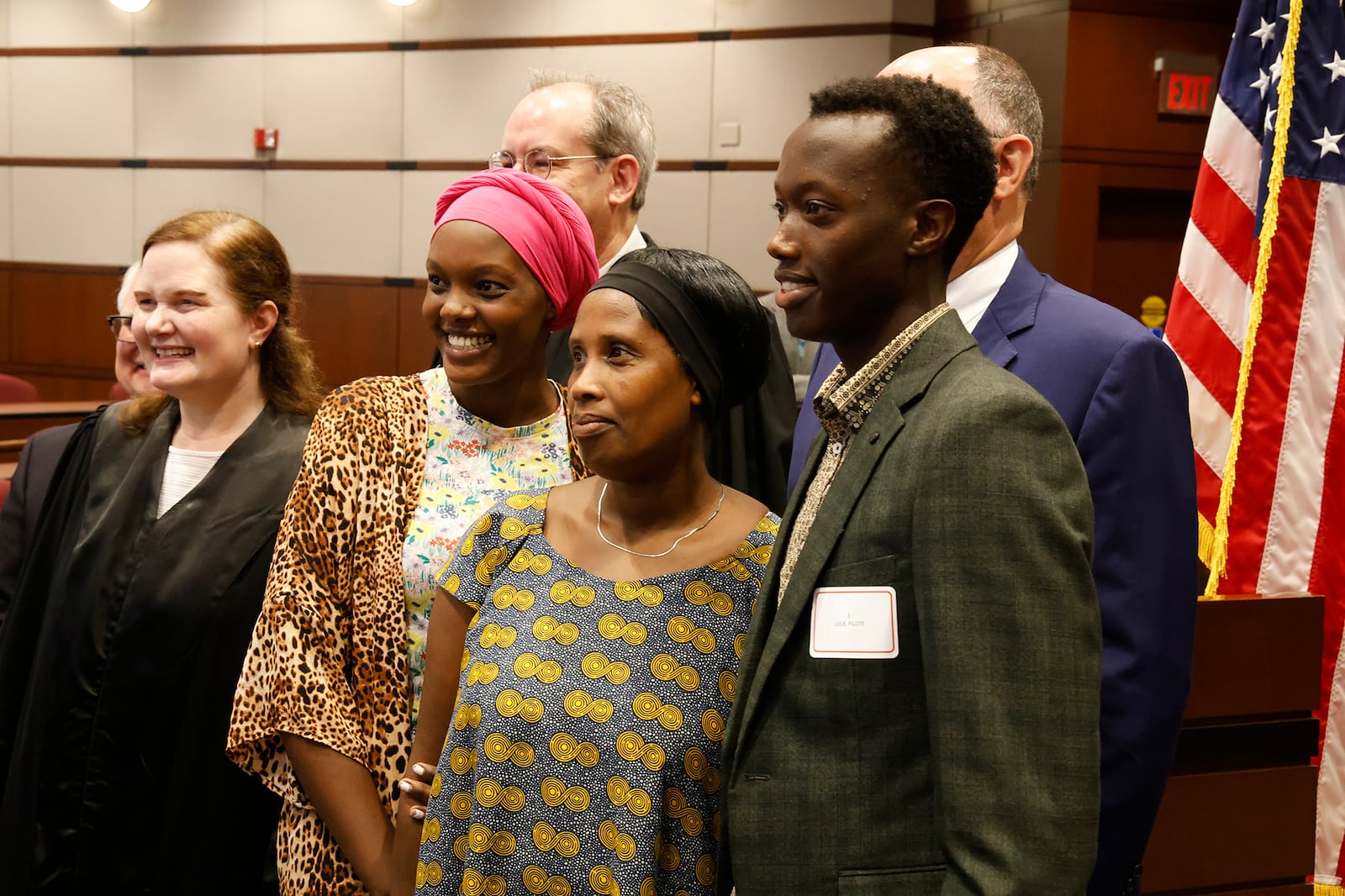 Pilote Luck (right), a native of the Democratic Republic of Congo who lives in Kettering,  poses for a picture with his family and officials, including U.S. District Court Magistrate Caroline H. Gentry (left), after being sworn in as a U.S. citizen on Monday, Sept. 18, 2023 at the University of Dayton School of Law. BILL LACKEY/STAFF