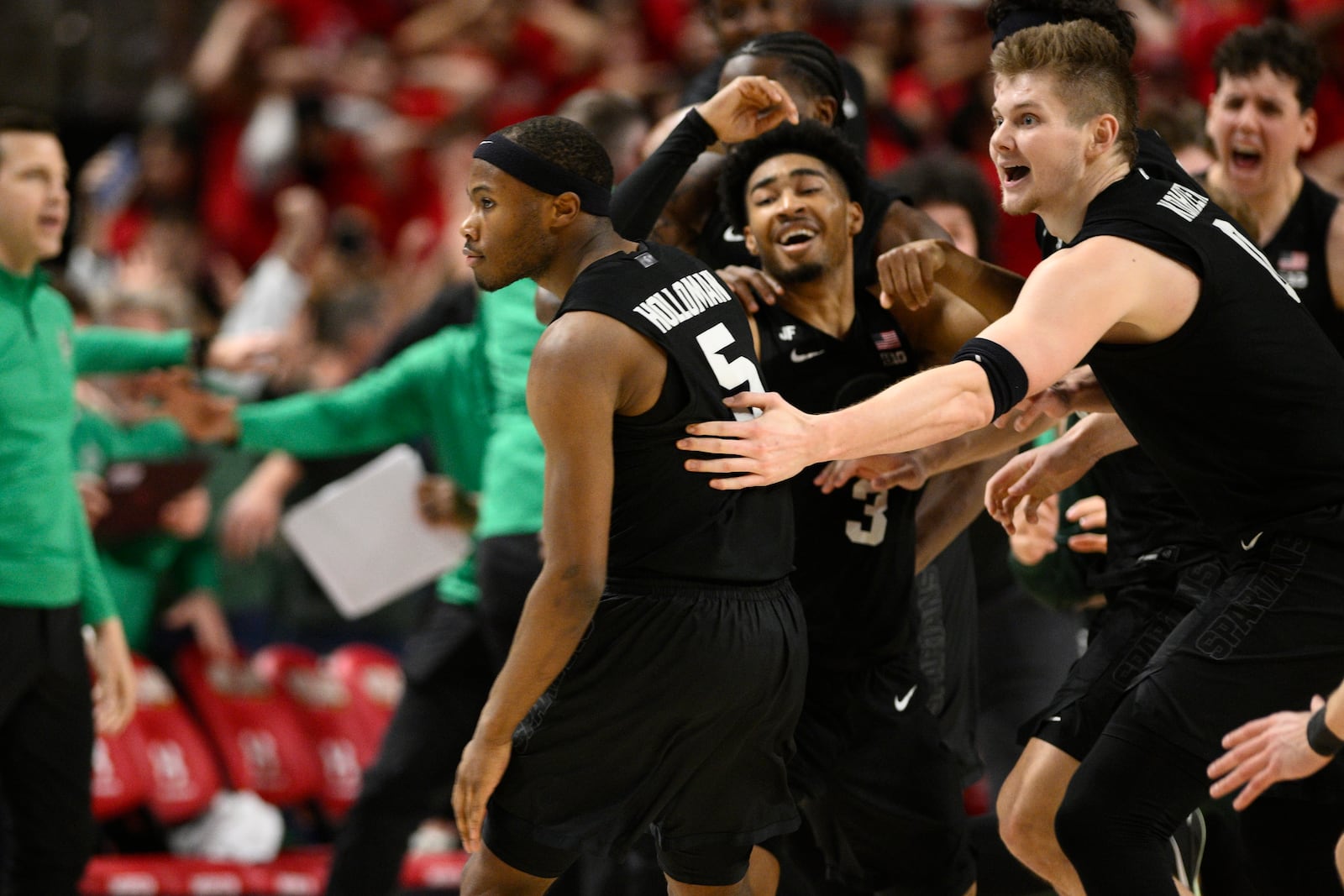 Michigan State guard Tre Holloman (5) and teammates celebrate after he made a game-winning basket to win the game at the buzzer during the second half of an NCAA college basketball game against Maryland, Wednesday, Feb. 26, 2025, in College Park, Md. (AP Photo/Nick Wass)