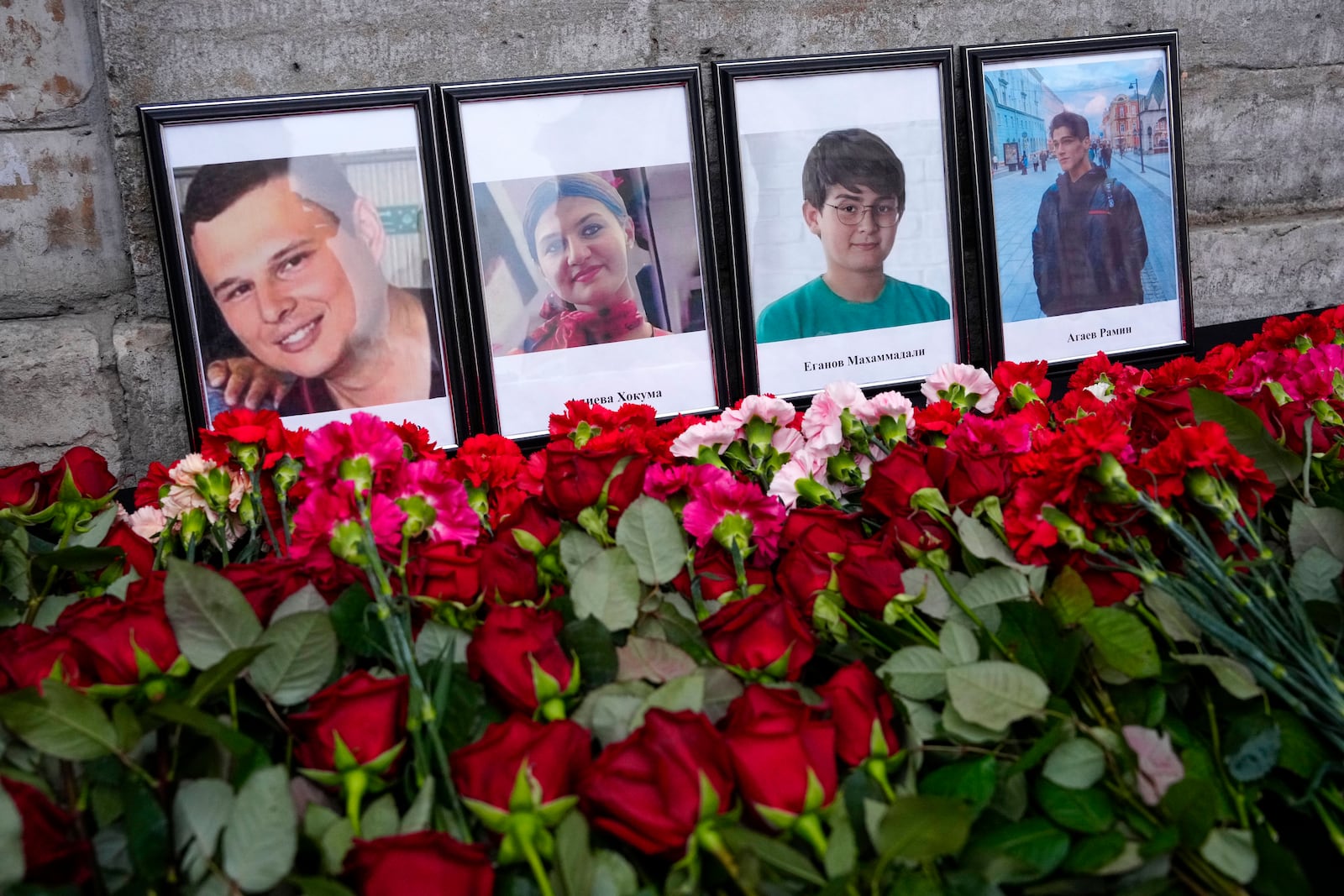 Flowers and portraits are placed at the Consulate of Azerbaijan in the memory of victims of the Azerbaijan Airlines' Embraer 190 that crashed near the Kazakhstan's airport of Aktau, in St. Petersburg, Russia, Thursday, Dec. 26, 2024. (AP Photo/Dmitri Lovetsky)