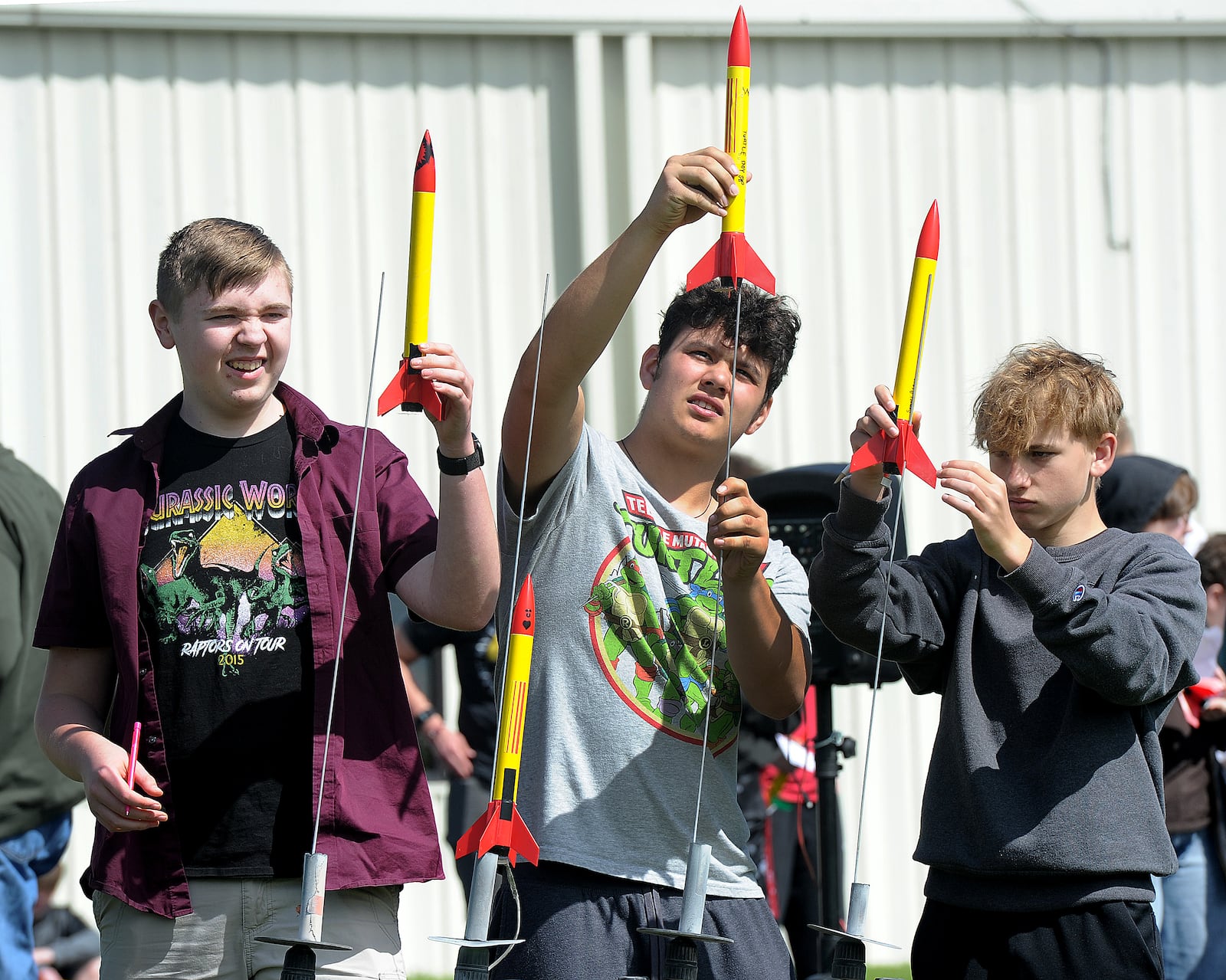 Xenia Community STE(A)M Academy, freshman students from left, Tyler Egli, Onyx Heathco and Samuel Brown prepare to launch their rockets Friday, May 10, 2024. MARSHALL GORBY\STAFF

