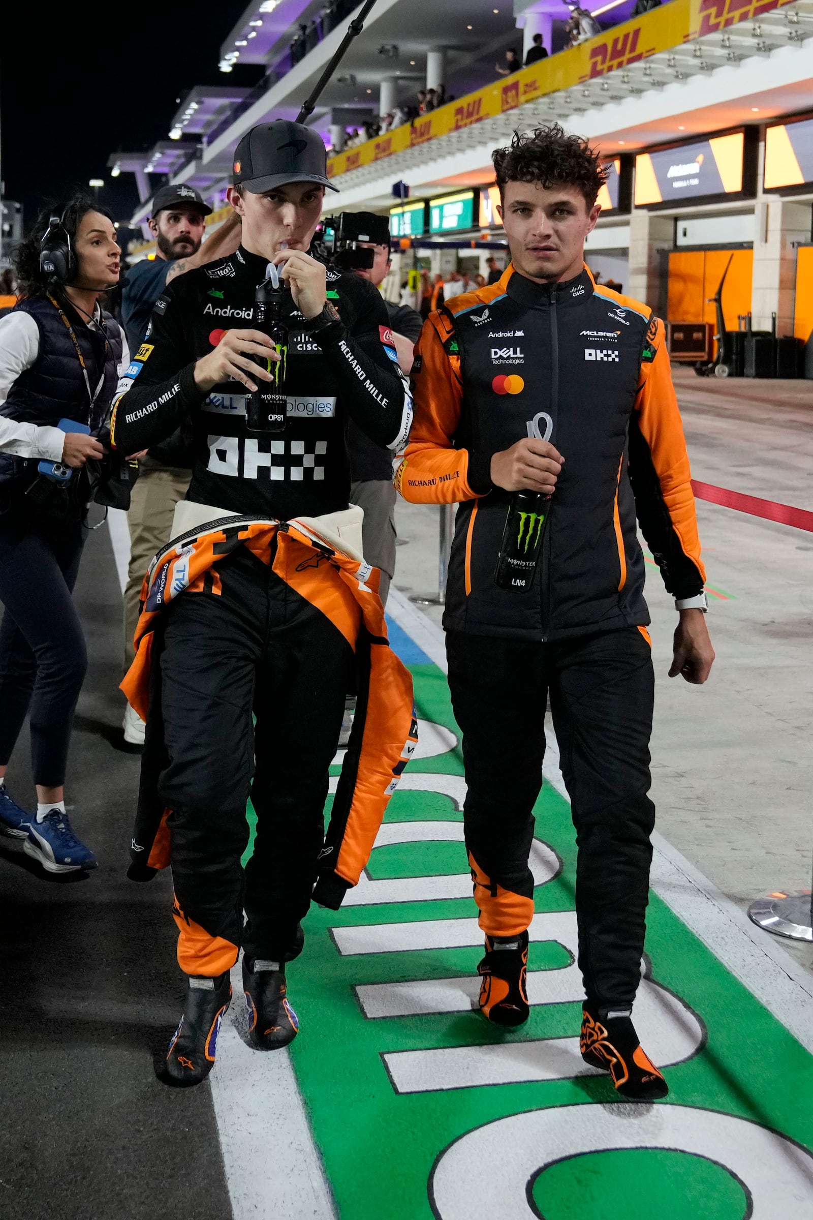 McLaren driver Oscar Piastri of Australia is flanked by his teammate Lando Norris of Britain after the sprint race at the Formula One Qatar Grand Prix, at the Lusail International Circuit in Lusail, Qatar, Saturday, Nov. 30, 2024. (AP Photo/ Altaf Qadri)