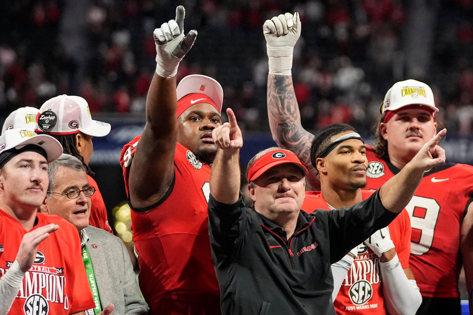 Georgia head coach Kirby Smart and players celebrate a win over Texas after the Southeastern Conference championship NCAA college football game, Saturday, Dec. 7, 2024, in Atlanta. (AP Photo/John Bazemore)