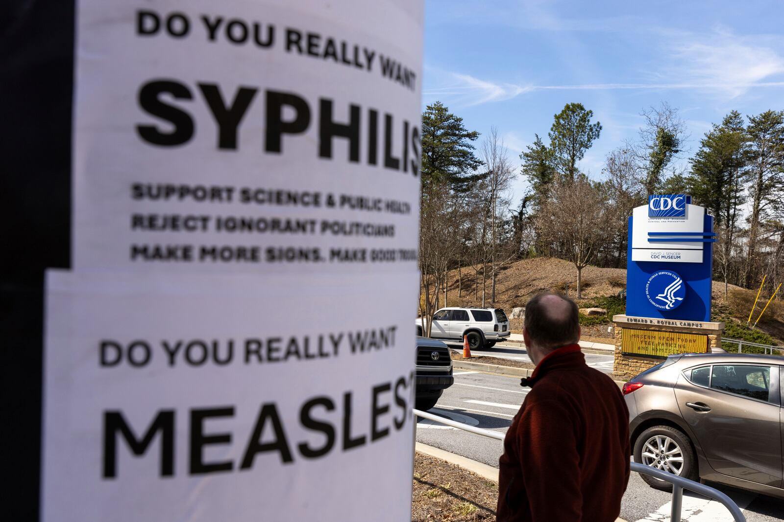 Demonstrators protest the mass firing of 1,000 Centers for Disease Control and Prevention (CDC) employees in front of the CDC headquarters in Atlanta on Tuesday, Feb. 18, 2025. (Arvin Temkar/Atlanta Journal-Constitution via AP)