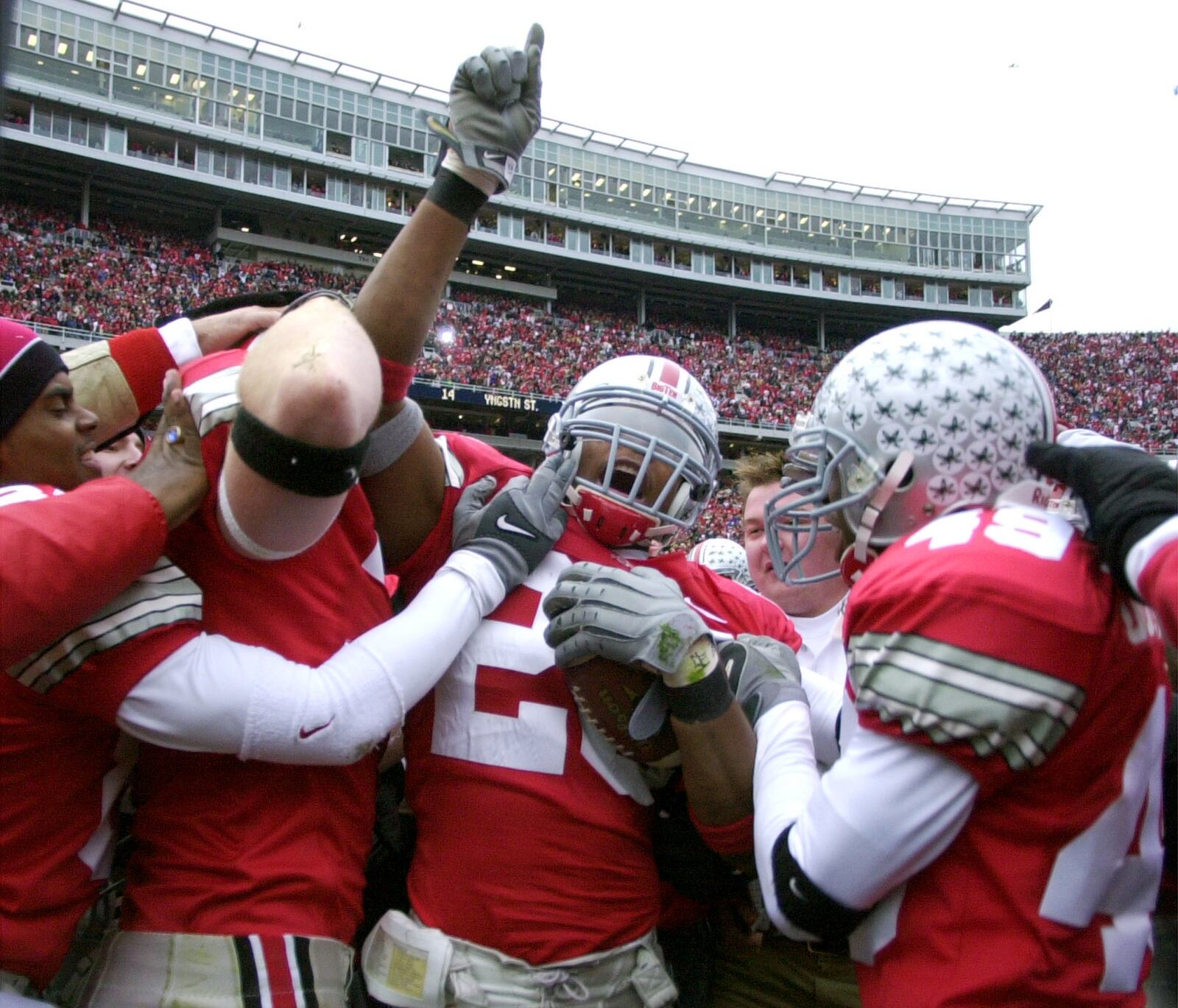 ** FILE **  In this Nov. 23, 2002 file photo, Ohio State free safety Will Allen (26) is mobbed by teammates in Columbus, Ohio after Allen intercepted a pass just short of the goal line on the football game's final play as the Buckeyes held off Michigan 14-9 to complete the regular season and set the table for the breathless bowl game. Celebrating with Allen are John Hollins (84) and E.J. Underwood (49). (AP Photo/Amy Sancetta, File)