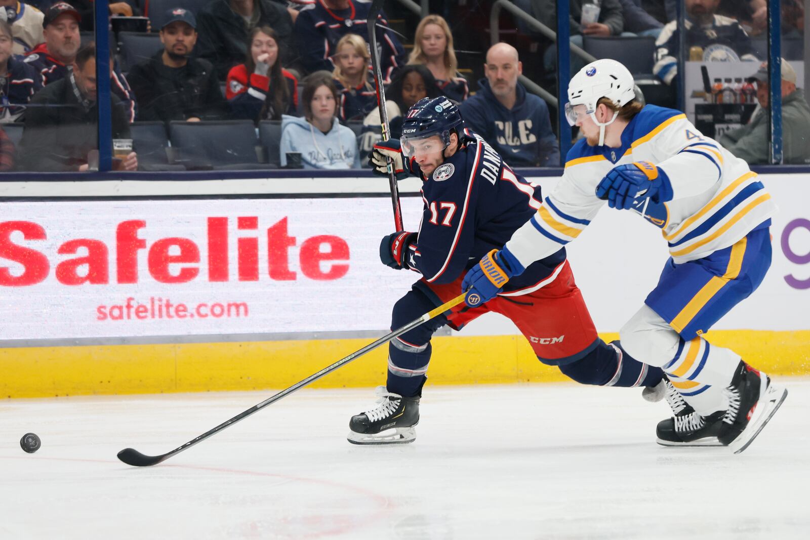 Columbus Blue Jackets' Justin Danforth, left, and Buffalo Sabres' Bowen Byram, right, chase the puck during the second period of an NHL hockey game Thursday, Oct. 17, 2024, in Columbus, Ohio. (AP Photo/Jay LaPrete)