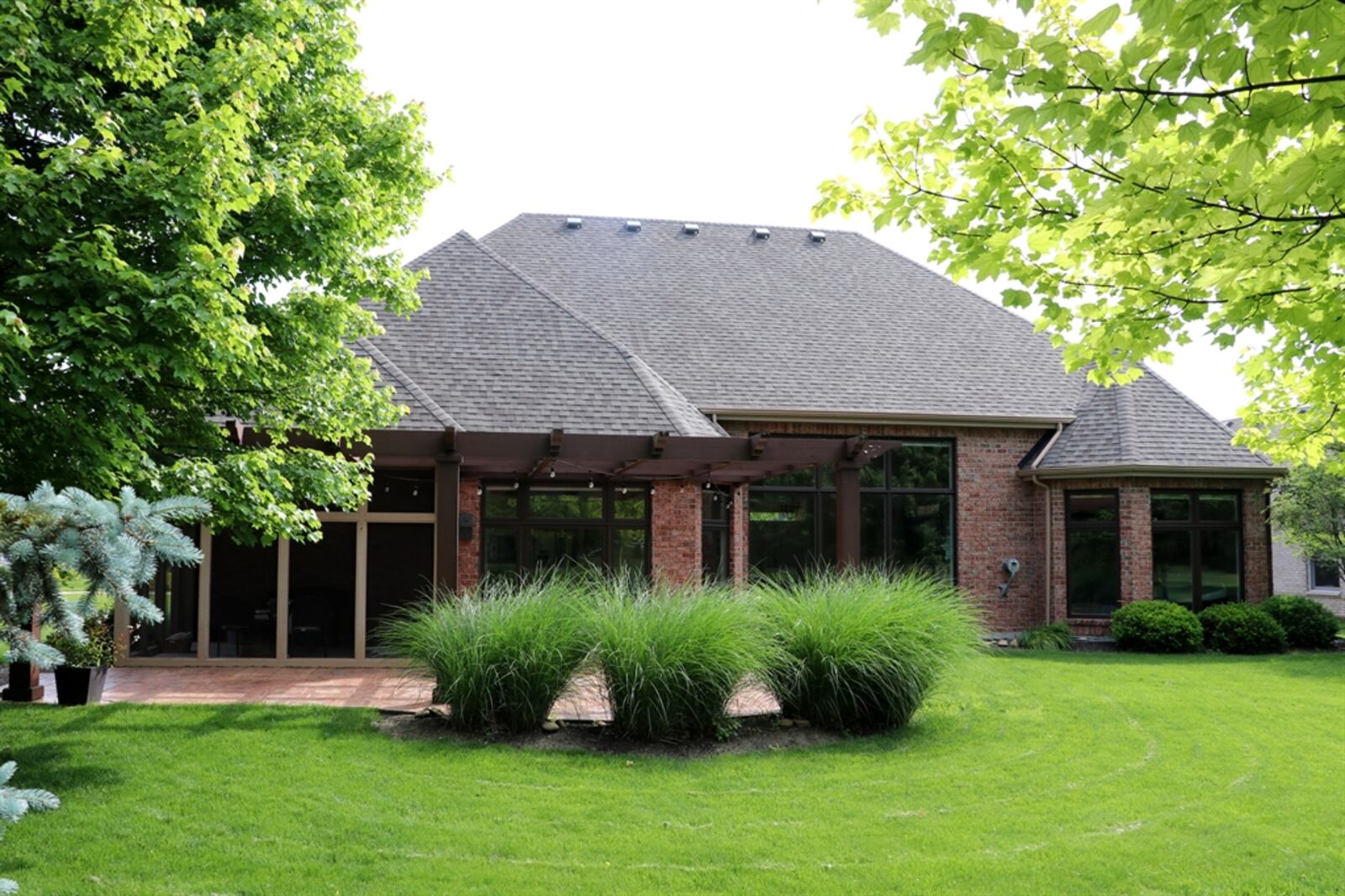 Walls of windows along the back of the house overlook the patio, gardens and fairway. CONTRIBUTED PHOTO BY KATHY TYLER