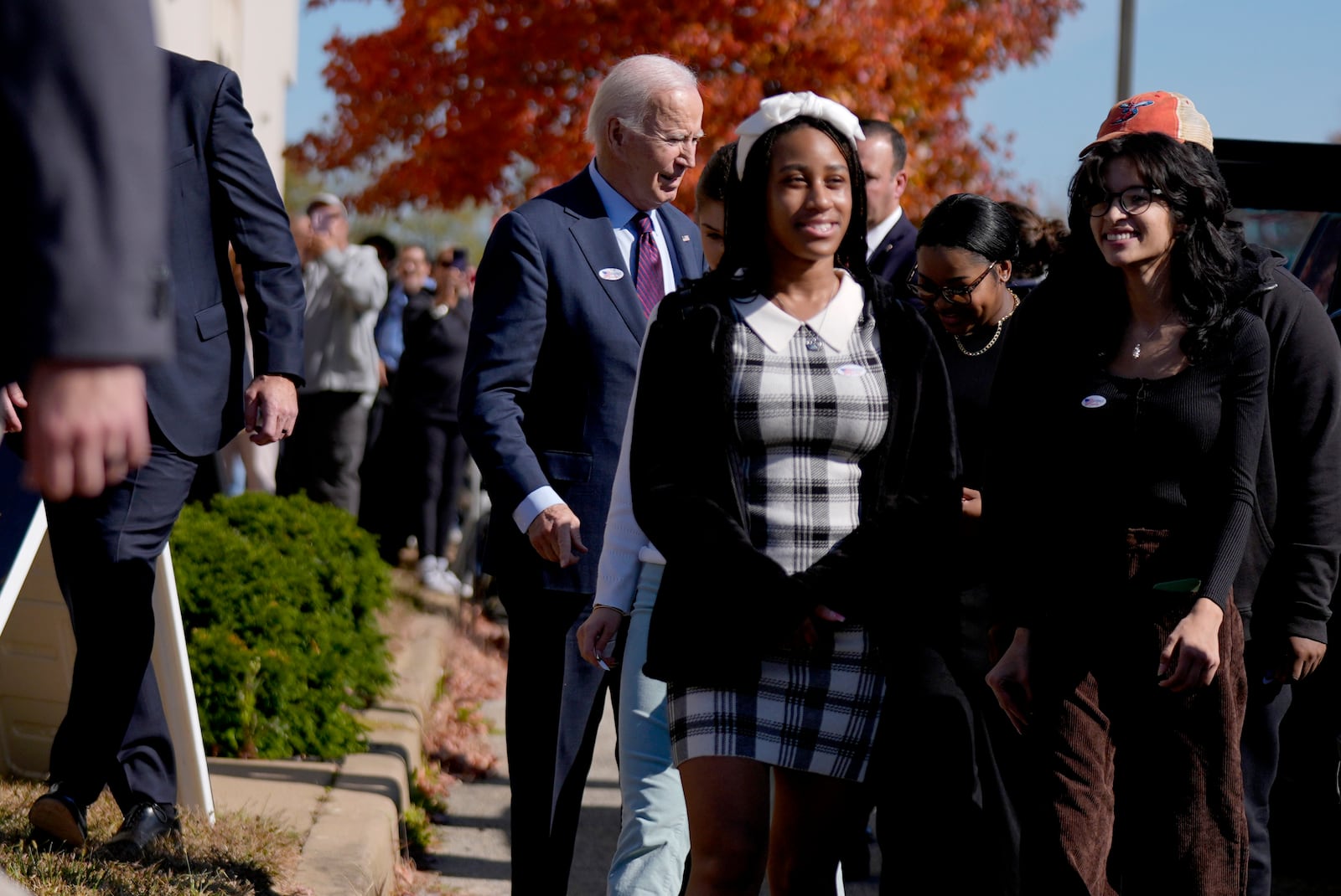 President Joe Biden, left, departs a polling station alongside first-time voters after casting his early-voting ballot for the 2024 general elections, Monday, Oct. 28, 2024, in New Castle, Del. (AP Photo/Manuel Balce Ceneta)