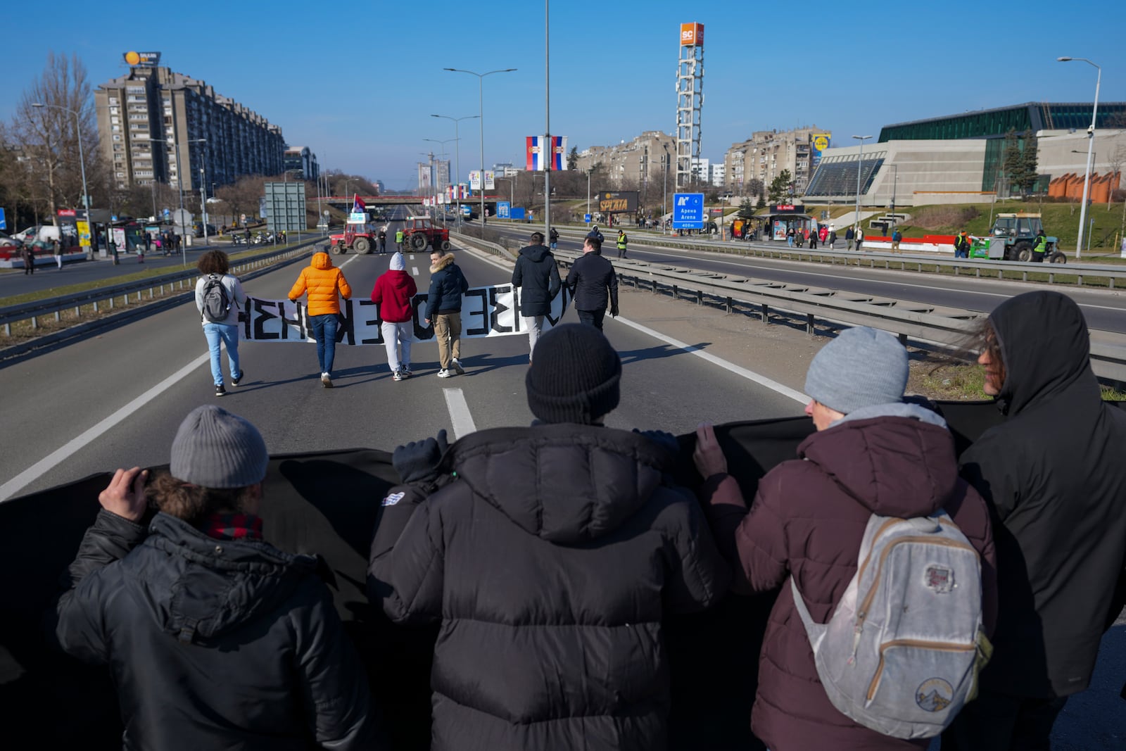 People participate in a 7-hour long blockade of a highway in Belgrade, Serbia, Sunday, Feb. 9, 2025, to protest the Nov. 1. collapse of a concrete canopy at the central train station in Novi Sad, that killed 15 people. (AP Photo/Darko Vojinovic)