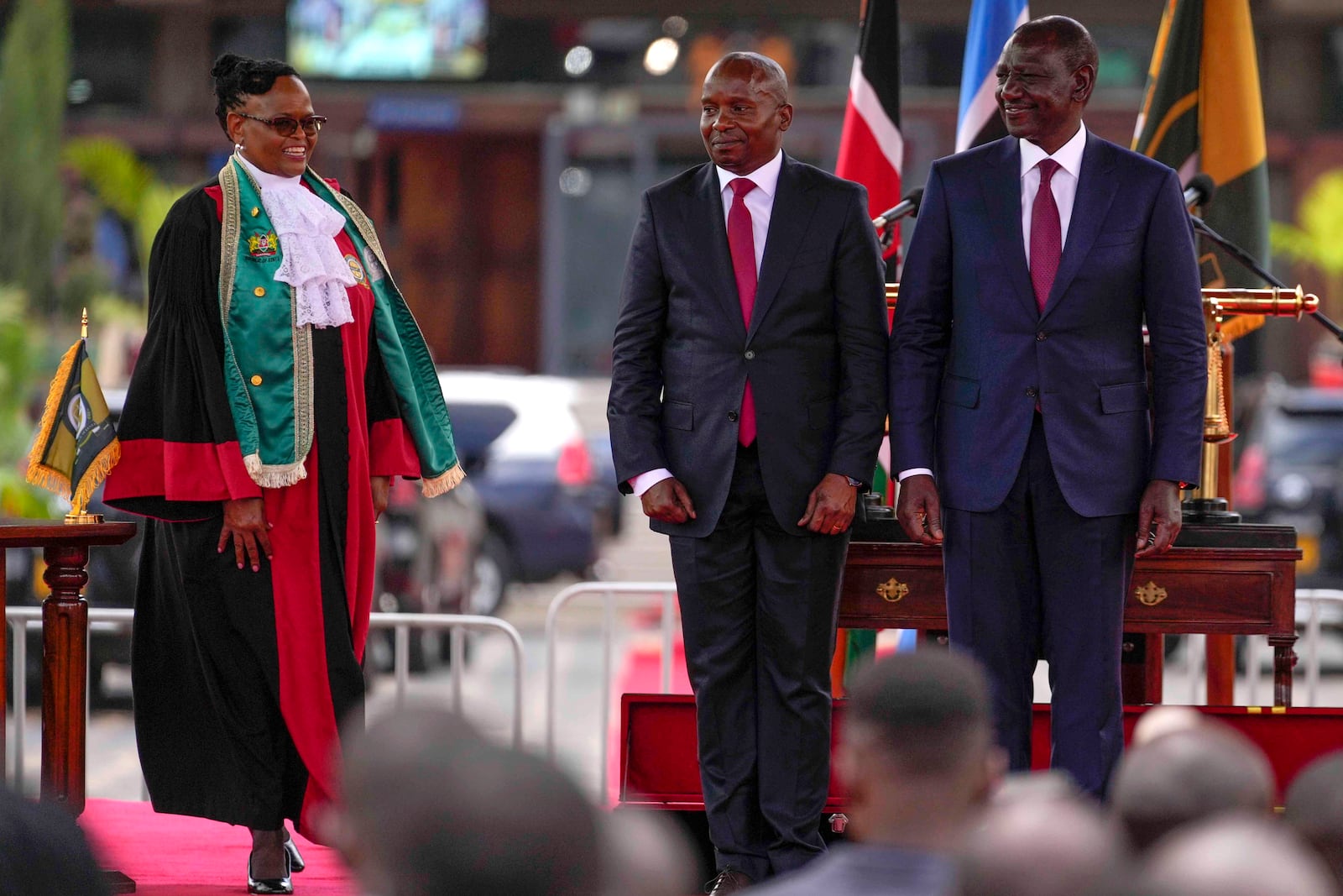 Kenya's new Deputy President Kithure Kindiki, center, is flanked by Kenyan President William Ruto, right, during his swearing in ceremony, at Kenyatta International Convention Centre, in Nairobi, Kenya Friday, Nov. 1, 2024. (AP Photo/Brian Inganga)