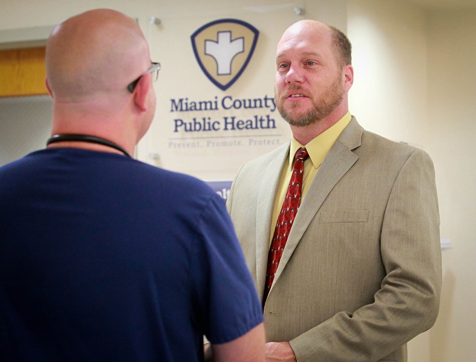 Dennis Propes, right, talks to Dr. Daniel Dilworth in the Miami County Health Department in Troy. FILE