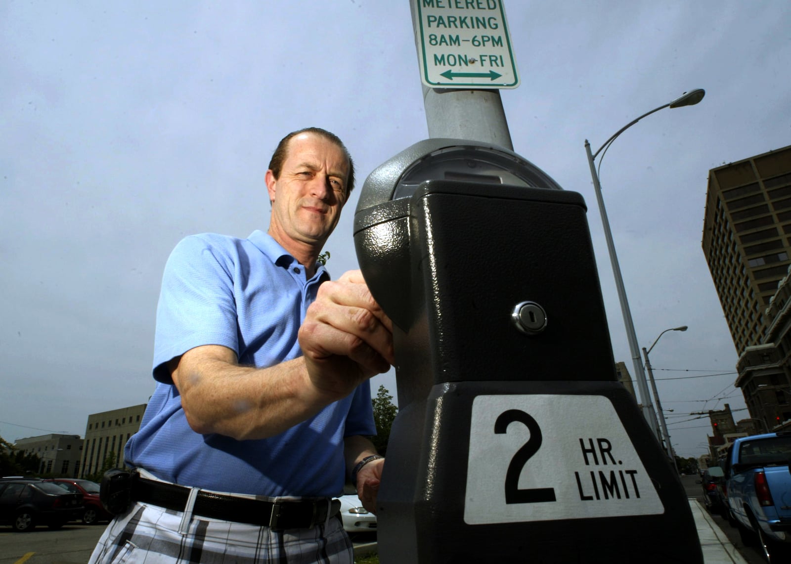 Archive photo: Dennis Earl of Huber Heights puts coins in a meter in downtown Dayton on Friday, July 1, 2011. (Staff photo by Chris Stewart)