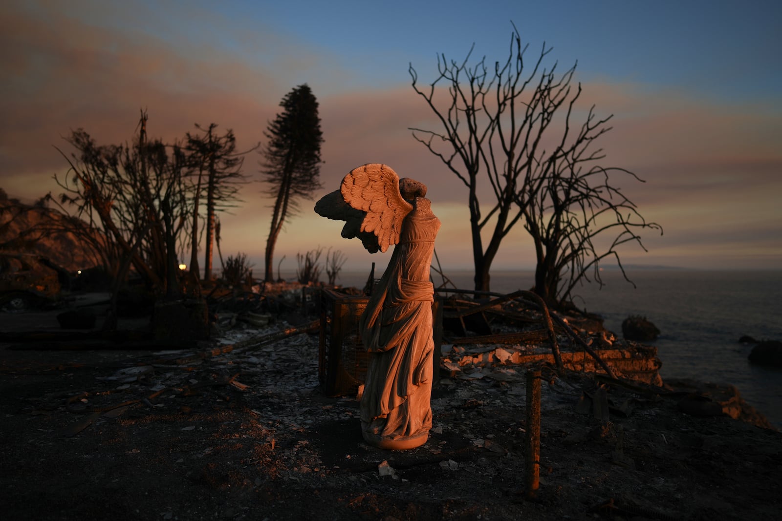 A statue stands amid damage from the Palisades Fire on Friday, Jan. 10, 2025, in Malibu, Calif. (AP Photo/Eric Thayer)