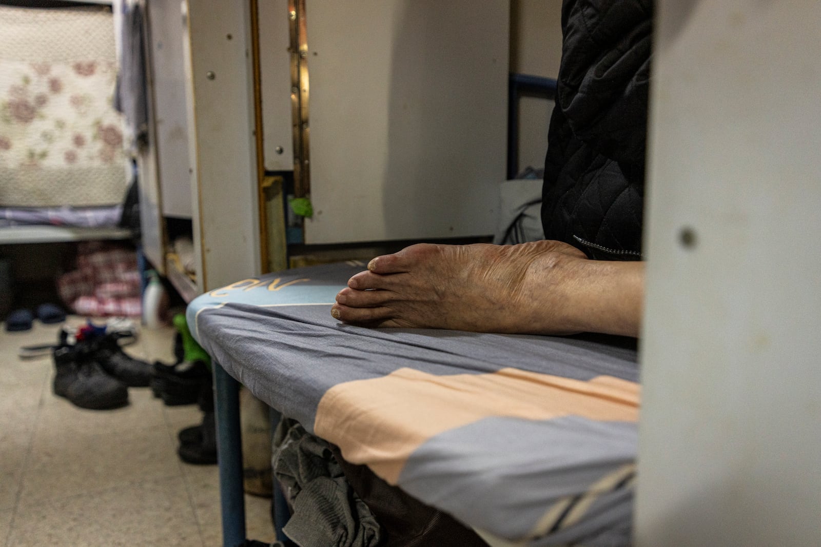 A resident rests in his bed space in Sham Shui Po district of Hong Kong, on Feb. 6, 2025. (AP Photo/Chan Long Hei)