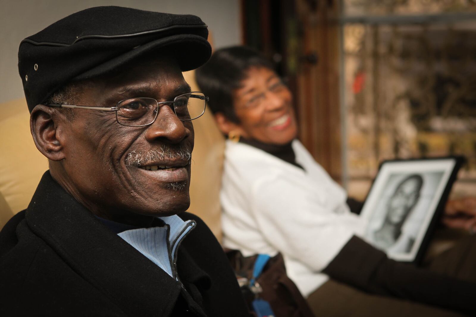 In the foreground is Ike Thornton, a teammate and friend of Roger Brown. In the background, Arlena Smith holds a portrait of Brown in his playing days in the 60's. STAFF FILE PHOTO