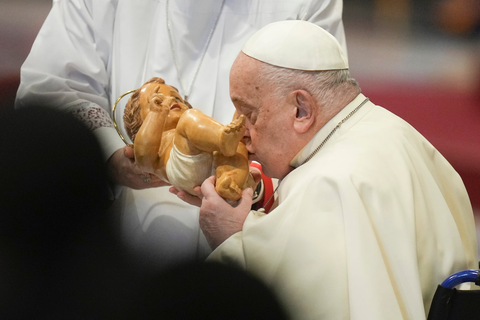 Pope Francis kisses the baby Jesus as he presides over an Epiphany mass in St.Peter's Basilica, at the Vatican, Monday, Jan. 6, 2025. (AP Photo/Alessandra Tarantino)